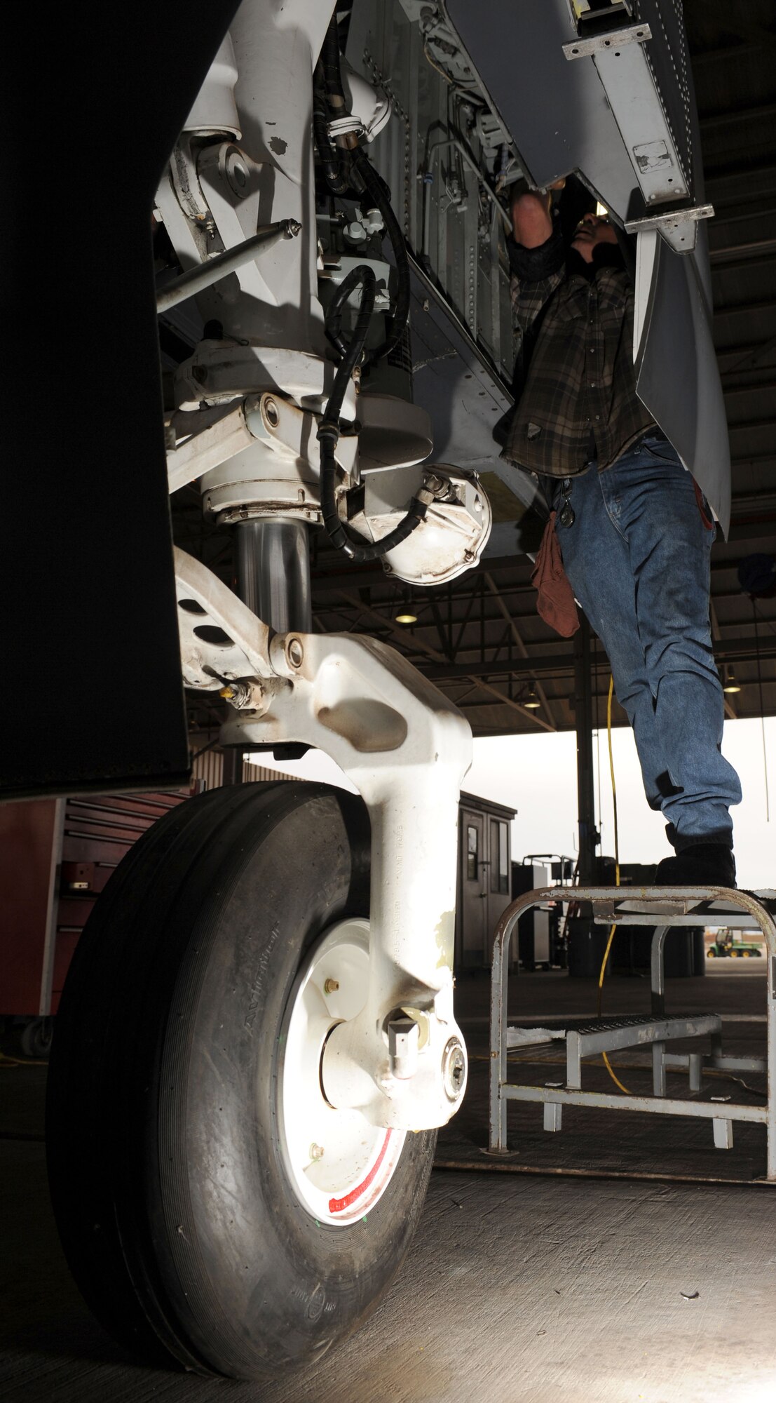 Kenneth Thompson, 576th Aerospace Maintenance and Regeneration Squadron aircraft mechanic, works inside the nose landing gear wheel well of an A-10A Thunderbolt on Davis-Monthan Air Force Base, Ariz., Jan. 24, 2013. Members of the 309th Aerospace Maintenance and Regeneration Group are ensuring the aircraft is safe and ready to fly. (U.S. Air Force photo by Senior Airman Timothy Moore/Released)