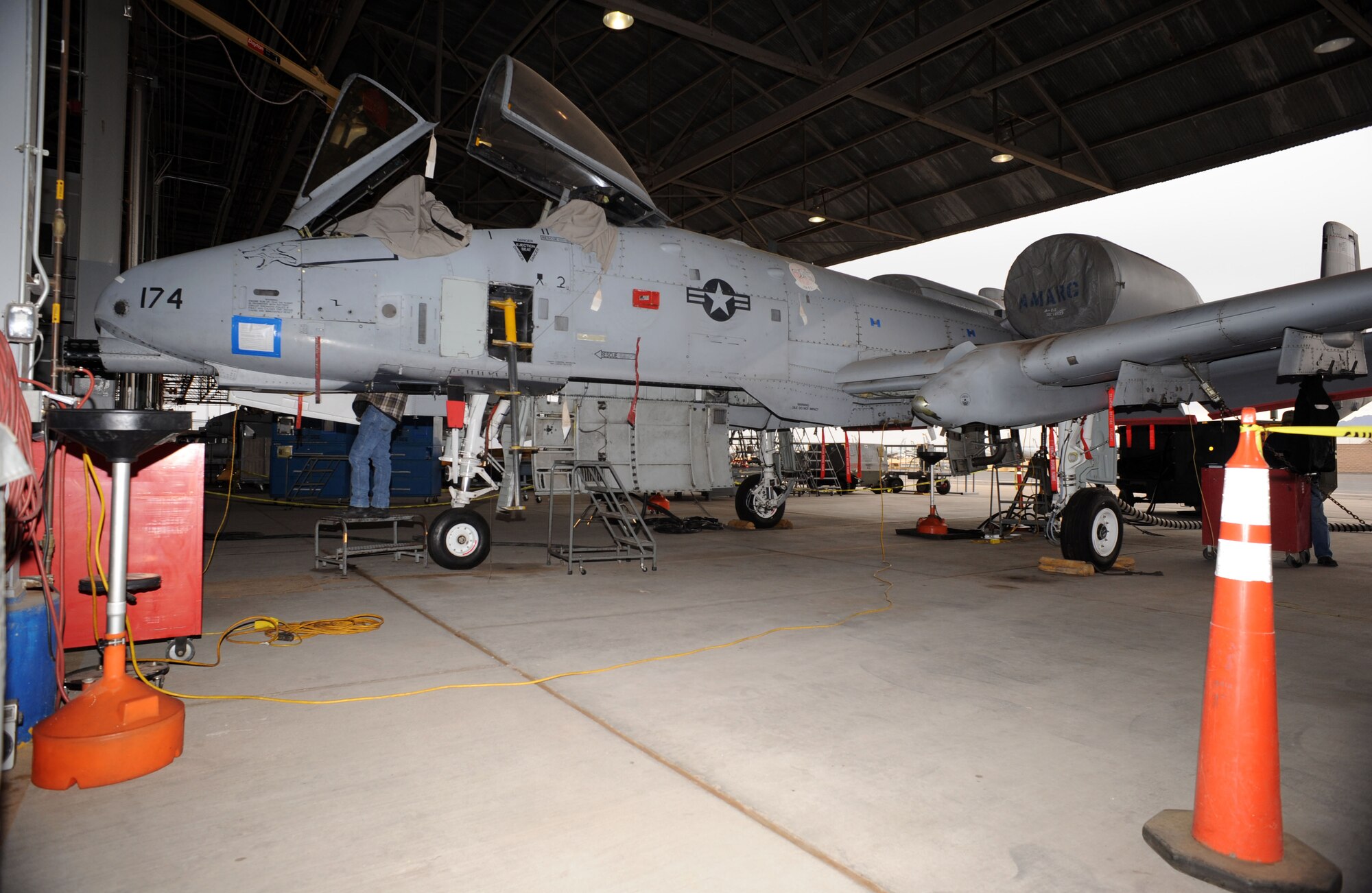 An A-10A Thunderbolt sits under a maintenance hangar on Davis-Monthan Air Force Base, Ariz., Jan. 24, 2013. This particular A-10, tail number 174, was used as a trainer for loading munitions on D-M and will now be used to track storms. (U.S. Air Force photo by Senior Airman Timothy Moore/Released)