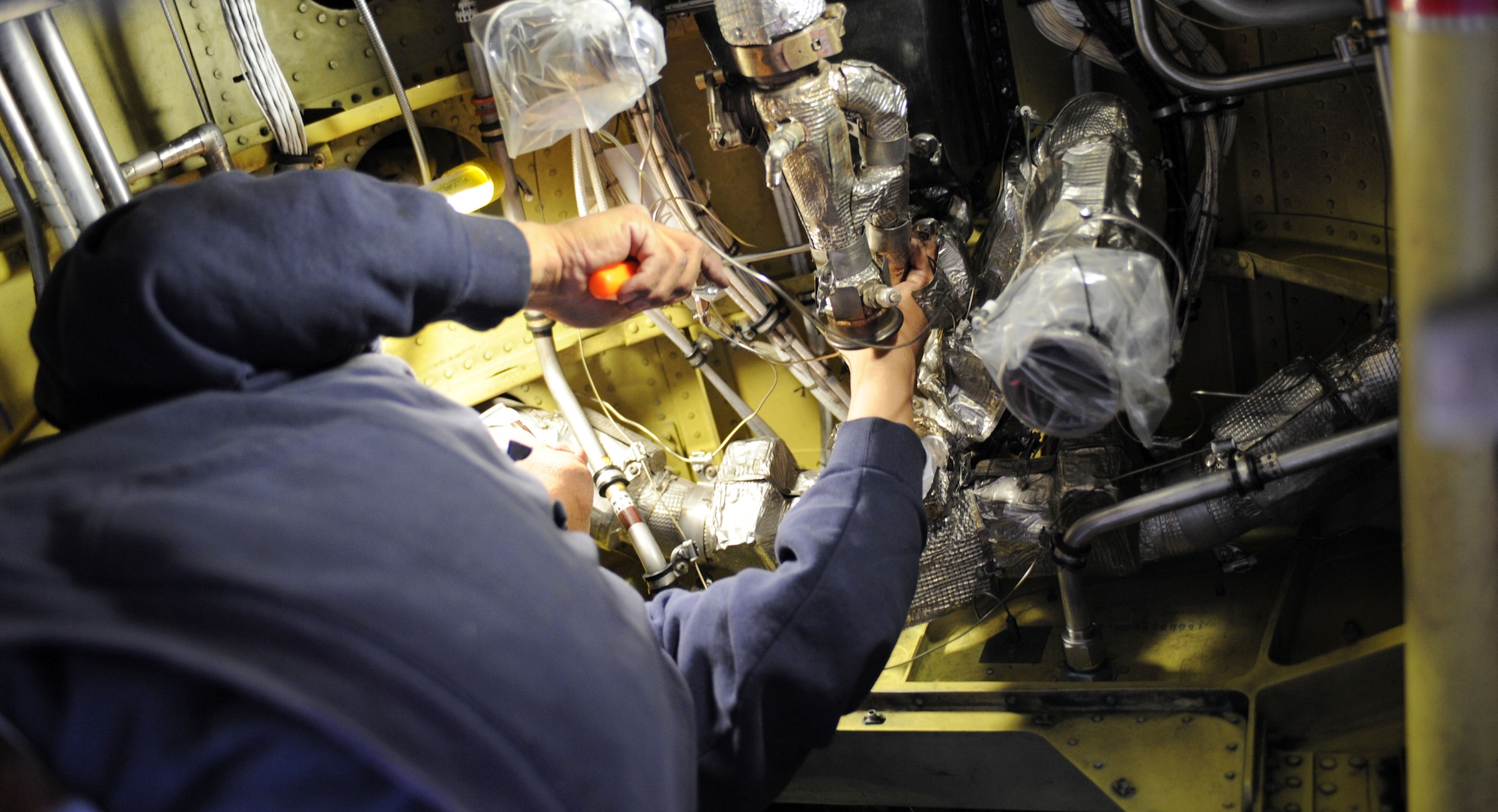 David Jaramillo, 576th Aerospace Maintenance and Regeneration Squadron aircraft mechanic, installs a portion of the heat exchange on an A-10A Thunderbolt on Davis-Monthan Air Force Base, Ariz., Jan. 23, 2013. Jaramillo and other members of the 309th Aerospace Maintenance and Regeneration Group are working to ensure the aircraft is safe and ready to fly. (U.S. Air Force photo by Senior Airman Timothy Moore/Released)