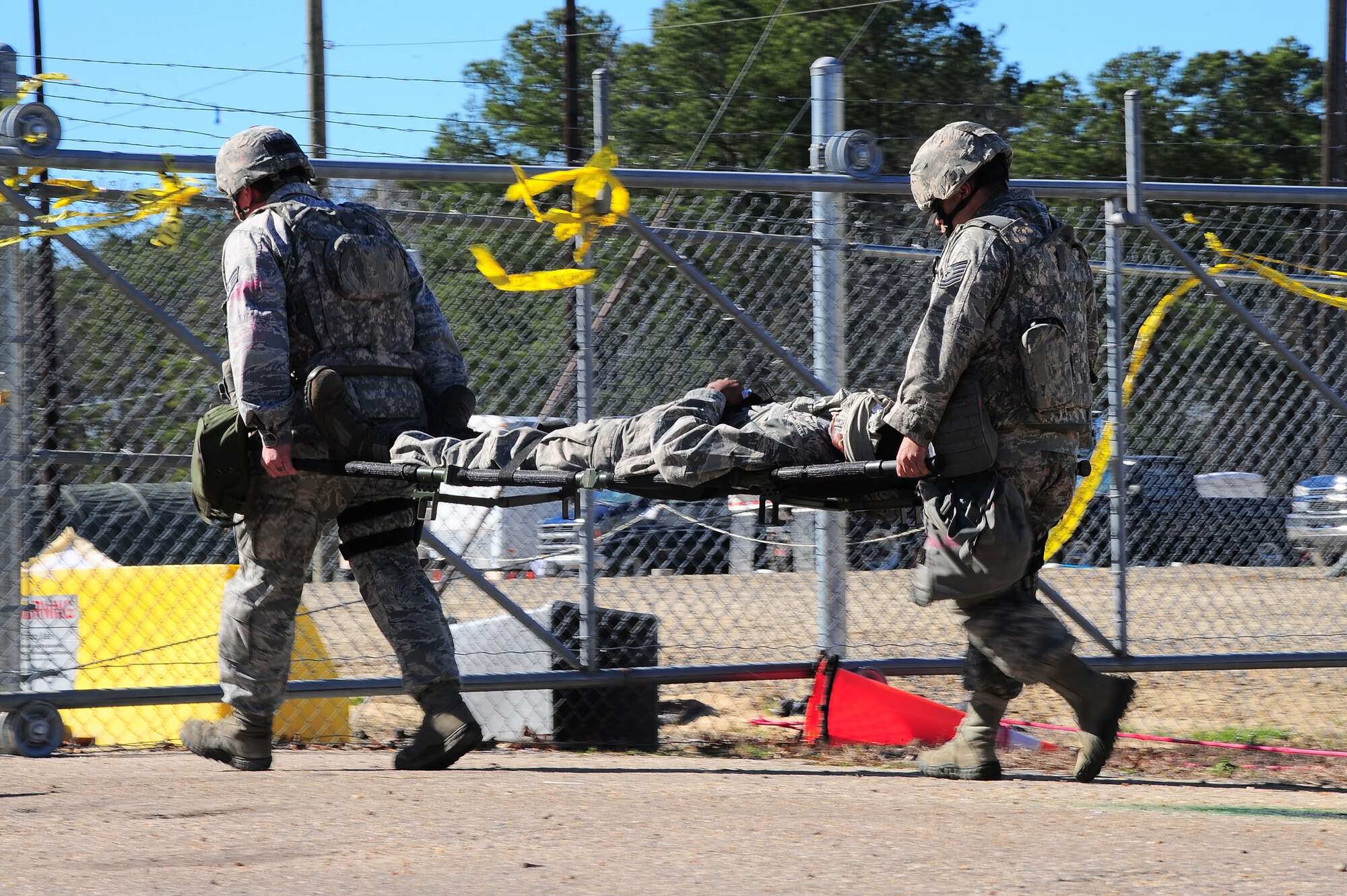 U.S. Air Force Airmen assigned to the 4th Security Forces Squadron carry a Airman to safety after a car-bombing and small arms fire scenario during Operational Readiness Exercise Coronet Warrior 13-01B, at a simulated deployed location on Seymour Johnson Air Force Base, N.C., Jan. 31, 2013. After on-scene personnel provide self-aid buddy care to their patients, they must provide transportation to the medical facility for further treatment. (U.S. Air Force photo/Airman 1st Class Aubrey White/Released)
