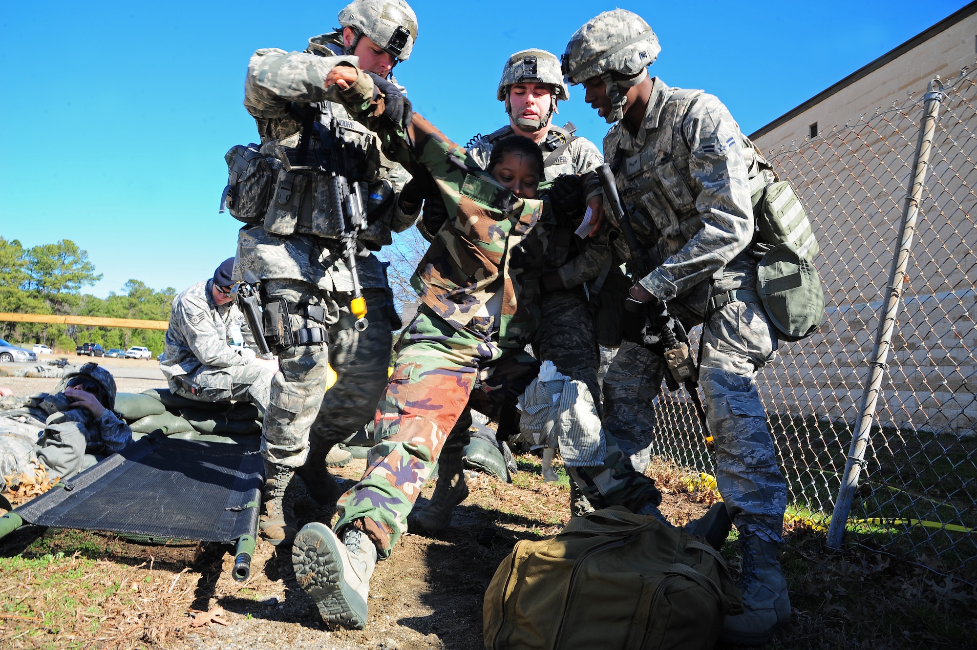 U.S. Air Force Airmen assigned to the 4th Security Forces Squadron attempt to lift a patient after a car-bombing and small arms fire scenario during Operational Readiness Exercise Coronet Warrior 13-01B, at a simulated deployed location on Seymour Johnson Air Force Base, N.C., Jan. 31, 2013. Personnel must provide on-scene medical attention to patients until they can transport the patient to the medical facility. (U.S. Air Force photo/Airman 1st Class Aubrey White/Released)