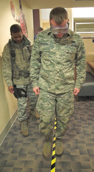 Staff Sgt. Anthony Leonard, 436th Security Forces Squadron response force leader, monitors Senior Airman Christopher Peterson, 436th Aerial Port Squadron air transportation, walk the line at the safety send off for Super Bowl weekend (DUI Prevention) at the Patterson Dining Facility Jan. 30, 2013, at Dover Air Force Base, Del. Walking the line is part of a fake field sobriety test to show Airmen what they would experience if they were pulled over for drinking and driving. (U.S. Air Force photo/Airman 1st Class Ashlin Federick)