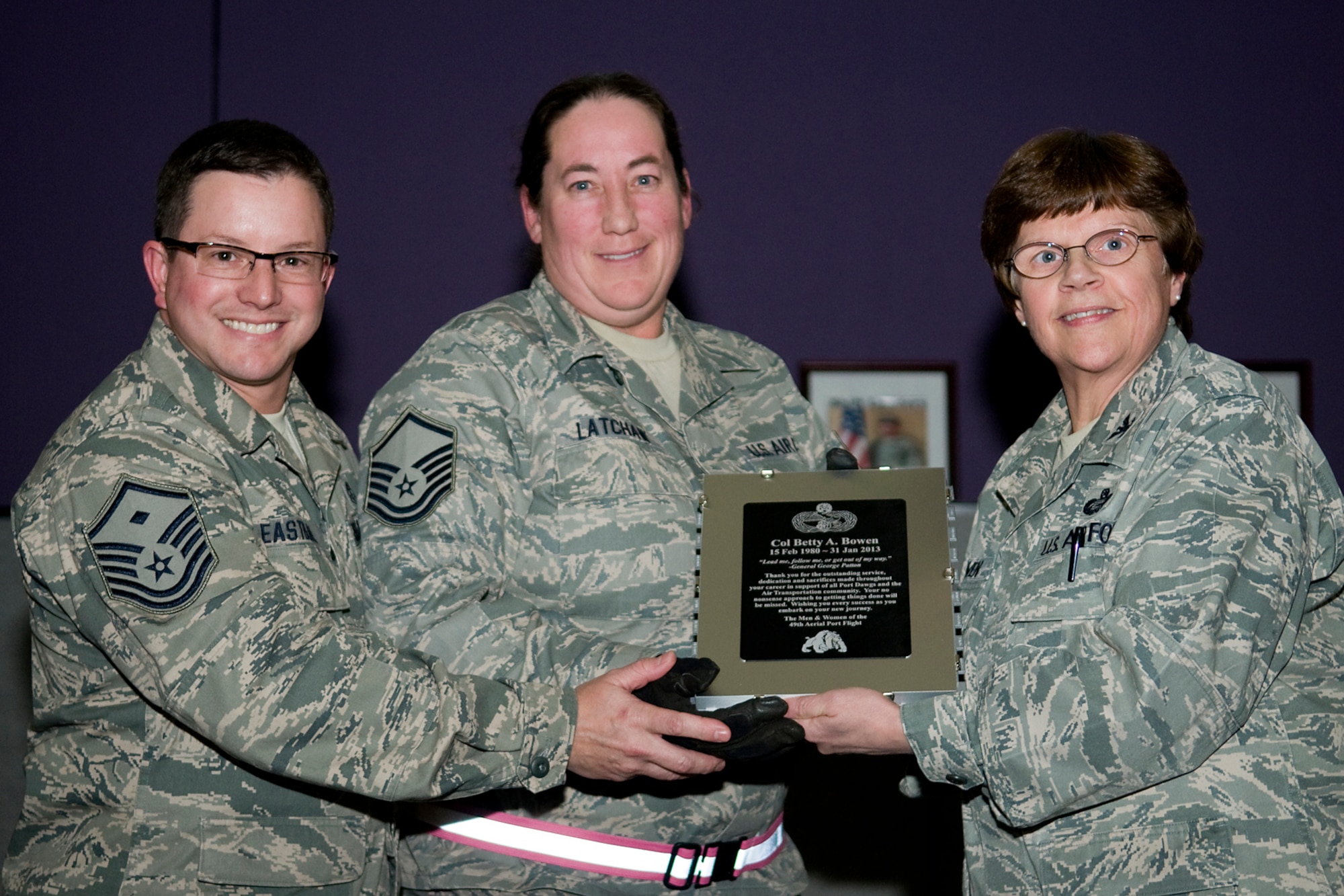 GRISSOM AIR RESERVE BASE, Ind. -- Master Sgt. Matt Eastburn, 49th Aerial Port Flight first sergeant, and Master Sgt. Laurie Latchaw , 49th APF deputy superintendent, present Col. Betty Bowen, 434th Mission Support Group commander with a plaque in the shape of an aircraft pallet in appreciation for her support and work as their commander. Bowen held her last commander's call in the Grissom dining facility Jan. 6 and officially retired on Jan. 31. (U.S. Air Force photo/Tech. Sgt. Mark R. W. Orders-Woempner)
