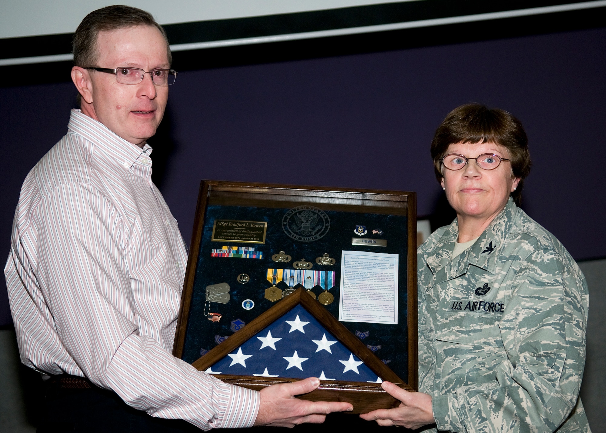 GRISSOM AIR RESERVE BASE, Ind. -- Col. Betty Bowen, 434th Mission Support Group commander, presents her husband, Bradford, a shadow box while thanking him for his support of her 32-year military career during her last commander's call here Jan. 6. According to Bowen, her husband sacrificed his own military career and was never able to retire as he supported her, moving around the country each time she took a new assignment. (U.S. Air Force photo/Tech. Sgt. Mark R. W. Orders-Woempner)
