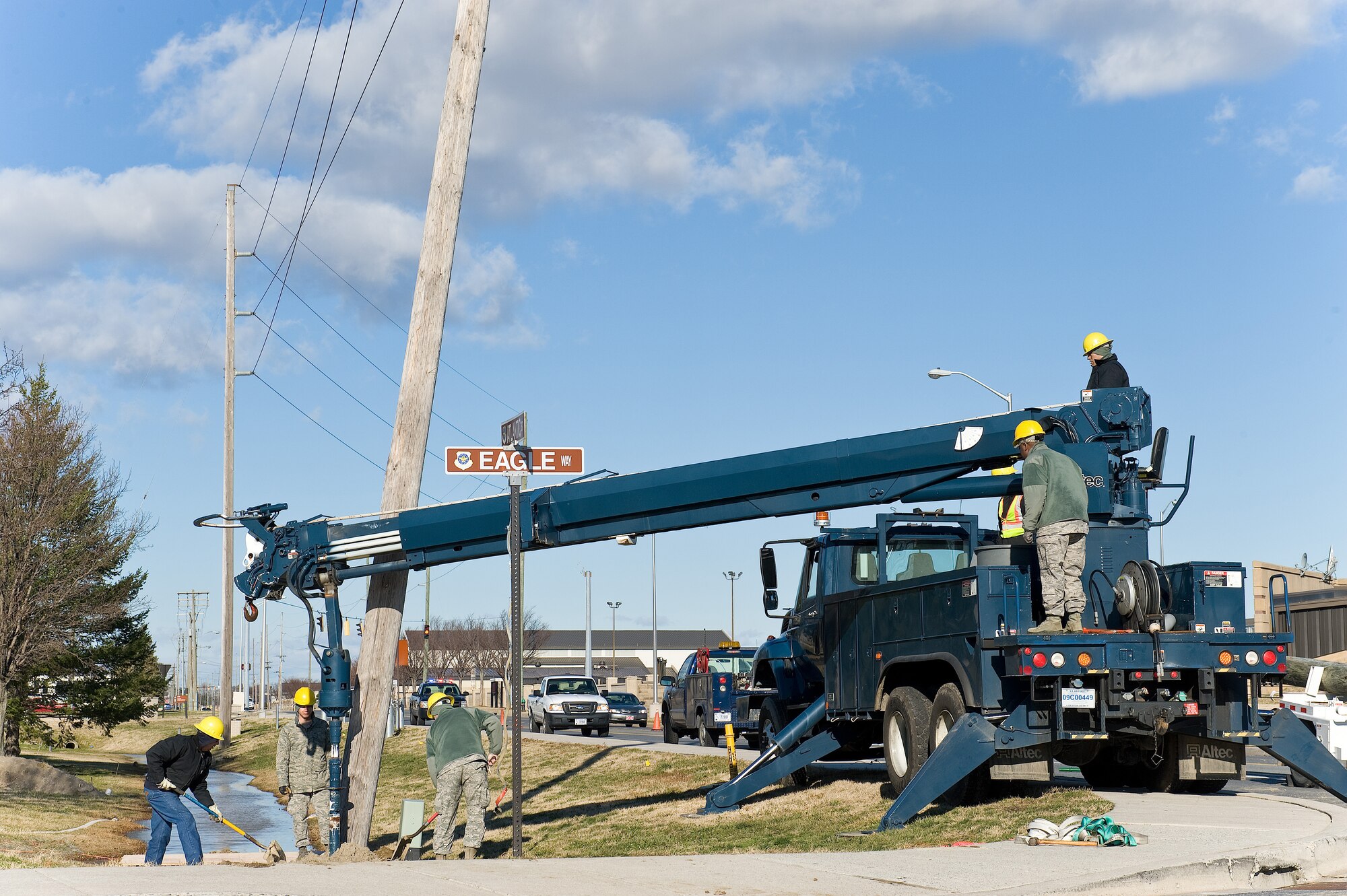 Members of the 436th Civil Engineer Squadron, Electric Shop, prepare to remove and replace a broken wood electric pole Jan. 31, 2013, at Dover Air Force Base, Del. The Electric Shop was called out after a strong cold front pushed through the region producing high winds and strong gusts up to 45 miles per hour, causing the pole to break at its base. (U.S. Air Force photo/Roland Balik)