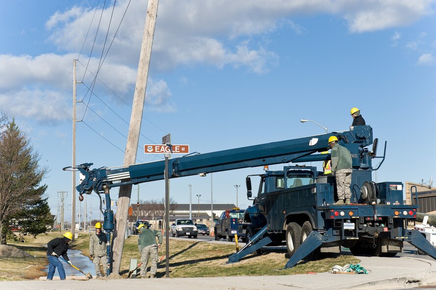 Members of the 436th Civil Engineer Squadron, Electric Shop, prepare to remove and replace a broken wood electric pole Jan. 31, 2013, at Dover Air Force Base, Del. The Electric Shop was called out after a strong cold front pushed through the region producing high winds and strong gusts up to 45 miles per hour, causing the pole to break at its base. (U.S. Air Force photo/Roland Balik)