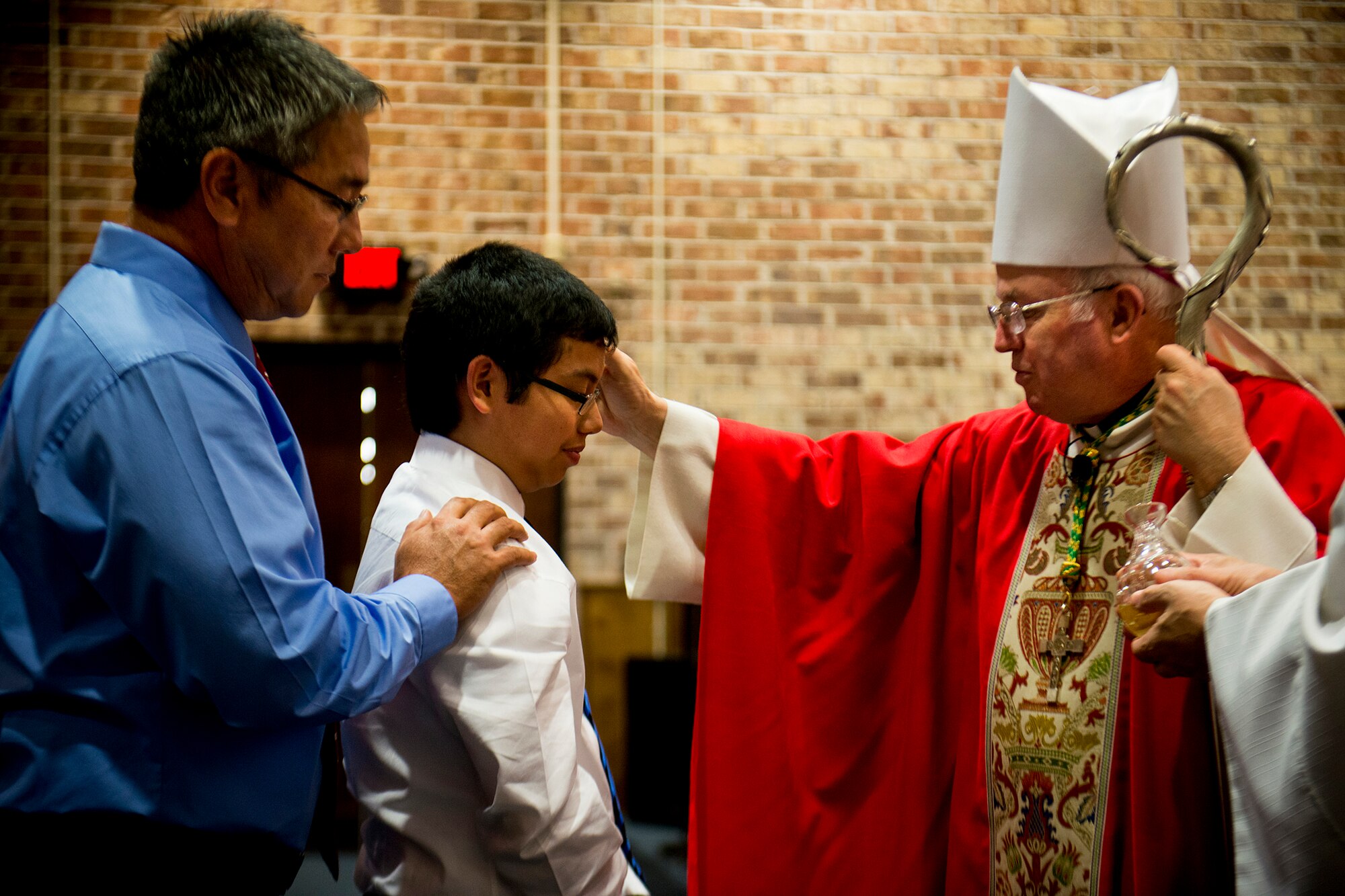 Bishop Richard Higgins, vicar for Veterans Affairs, seals Brandon Thorson with the Sacrament of Confirmation during Confirmation Mass Jan. 29, 2013, at the Moody Air Force Base, Ga., chapel. Brandon is the son of U.S. Air Force Master Sgt. Erin Thorson, 23d Wing plans and programs. (U.S. Air Force photo by Staff Sgt. Jamal D. Sutter/Released)  