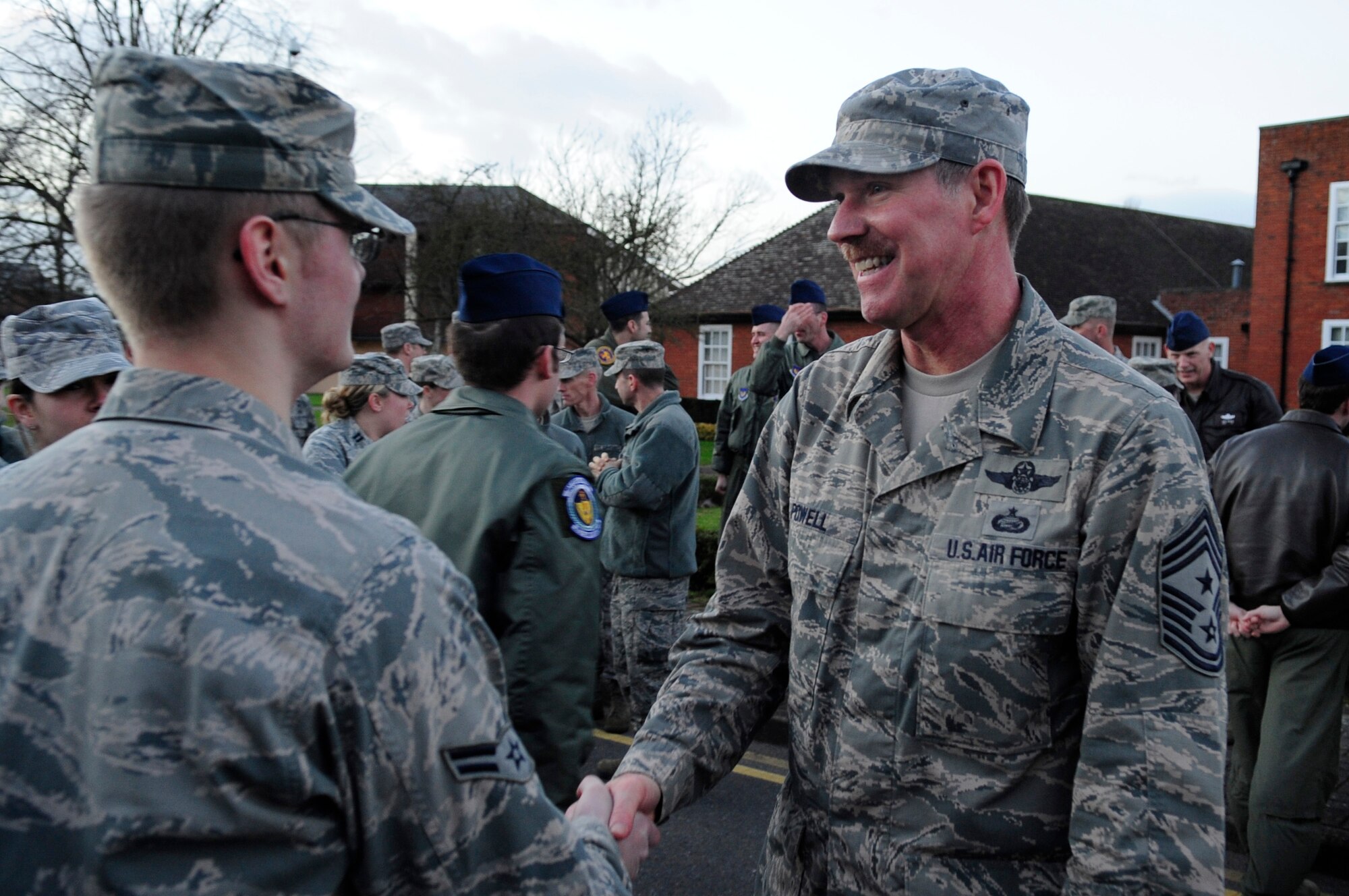 Chief Master Sgt. Christopher Powell, 100th Air Refueling Wing command chief, shakes hands with a Team Mildenhall Airman following a retreat ceremony Jan. 30, 2013, at RAF Mildenhall, England. The ceremony was held in honor of Powell as he prepares to retire from active duty. (U.S. Air Force photo by Airman 1st Class Dillon Johnston/Released)