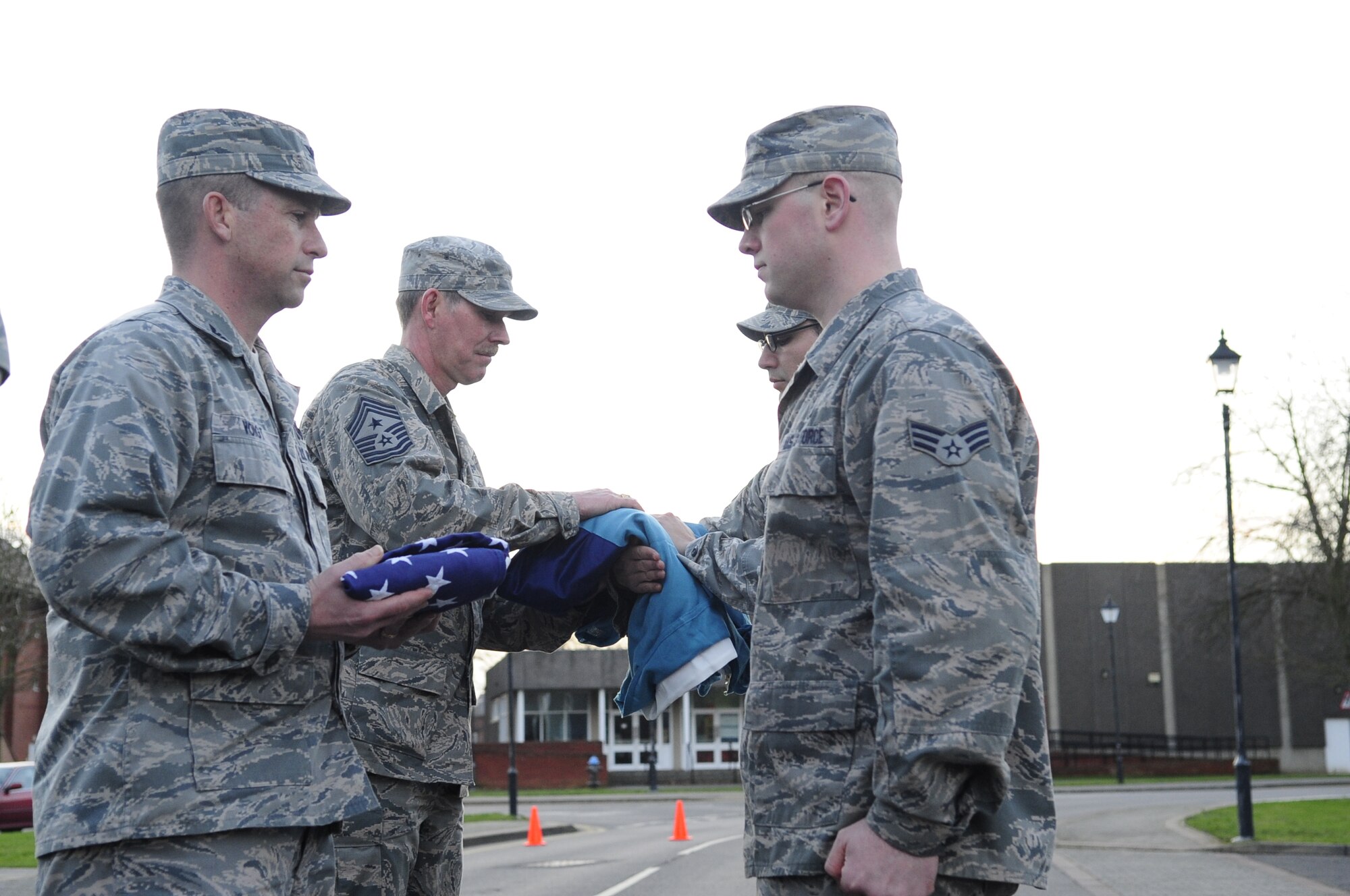 Chief Master Sgt. Christopher Powell, 100th Air Refueling Wing command chief, receives the Royal Air Force flag during a retreat ceremony Jan. 30, 2013, at RAF Mildenhall, England. The ceremony was held in honor of Powell as he prepares to retire from active duty. (U.S. Air Force photo by Airman 1st Class Dillon Johnston/Released)