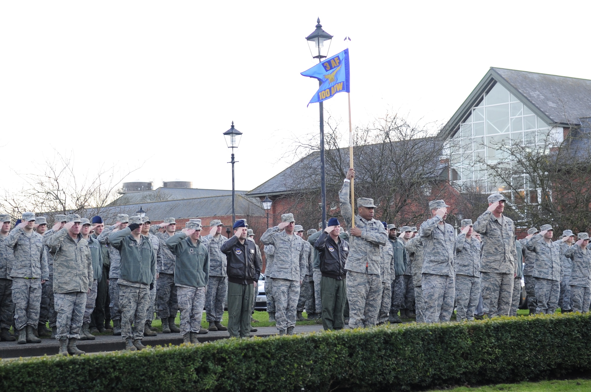 Chief Master Sgt. Christopher Powell, 100th Air Refueling Wing command chief, along with members of Team Mildenhall, salute during retreat Jan. 30, 2013, at RAF Mildenhall, England. This was Powell's last retreat before retiring from active duty. (U.S. Air Force photo by Airman 1st Class Dillon Johnston)