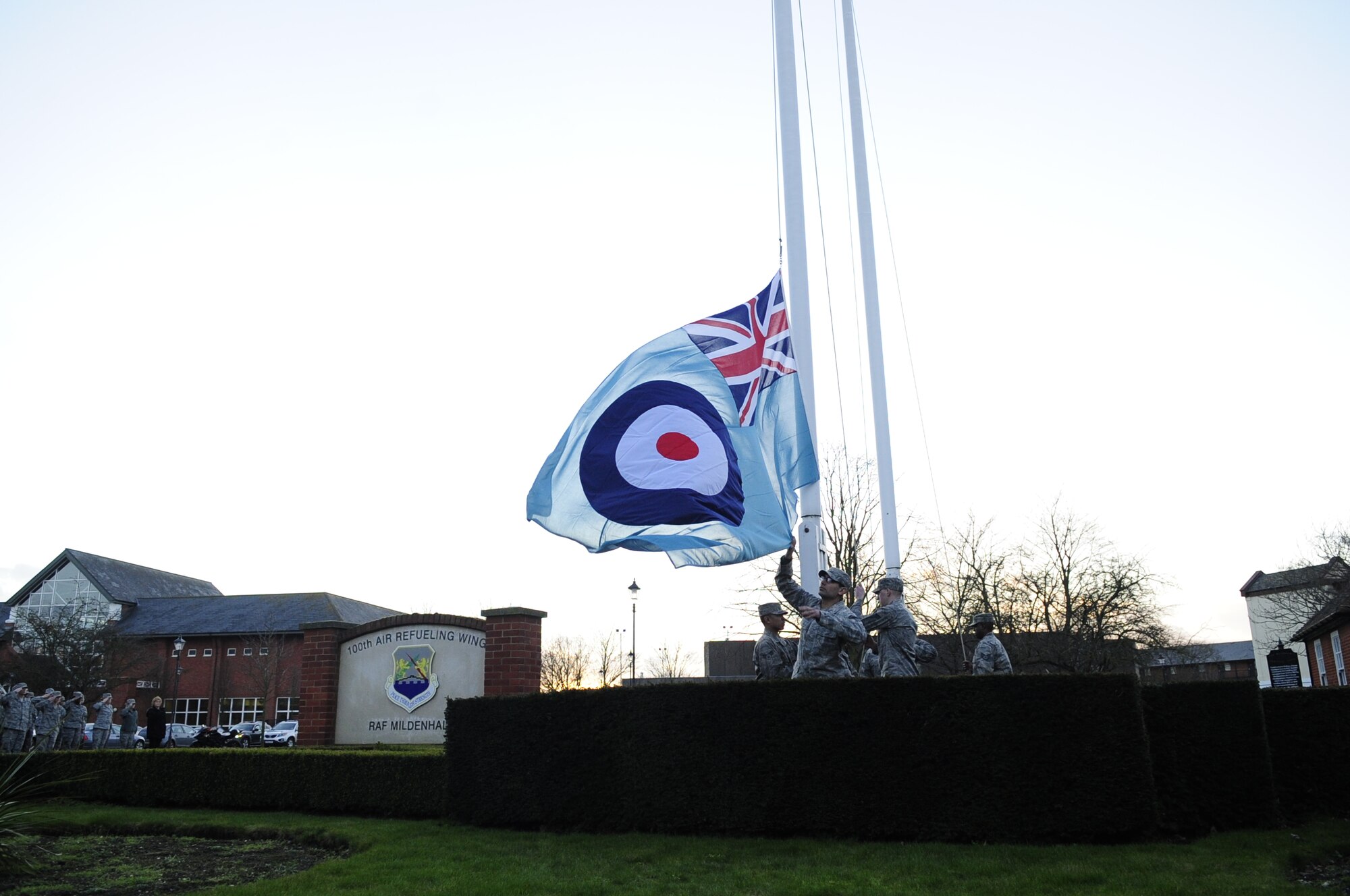 Team Mildenhall honor guardsmen retrieve a Royal Air Force flag as it is lowered during a retreat ceremony Jan. 30, 2013, at RAF Mildenhall, England. Airmen from multiple squadrons participated in the ceremony to honor Chief Master Sgt. Christopher Powell, 100th Air Refueling Wing command chief’s, upcoming retirement. (U.S. Air Force photo by Airman 1st Class Dillon Johnston/Released)