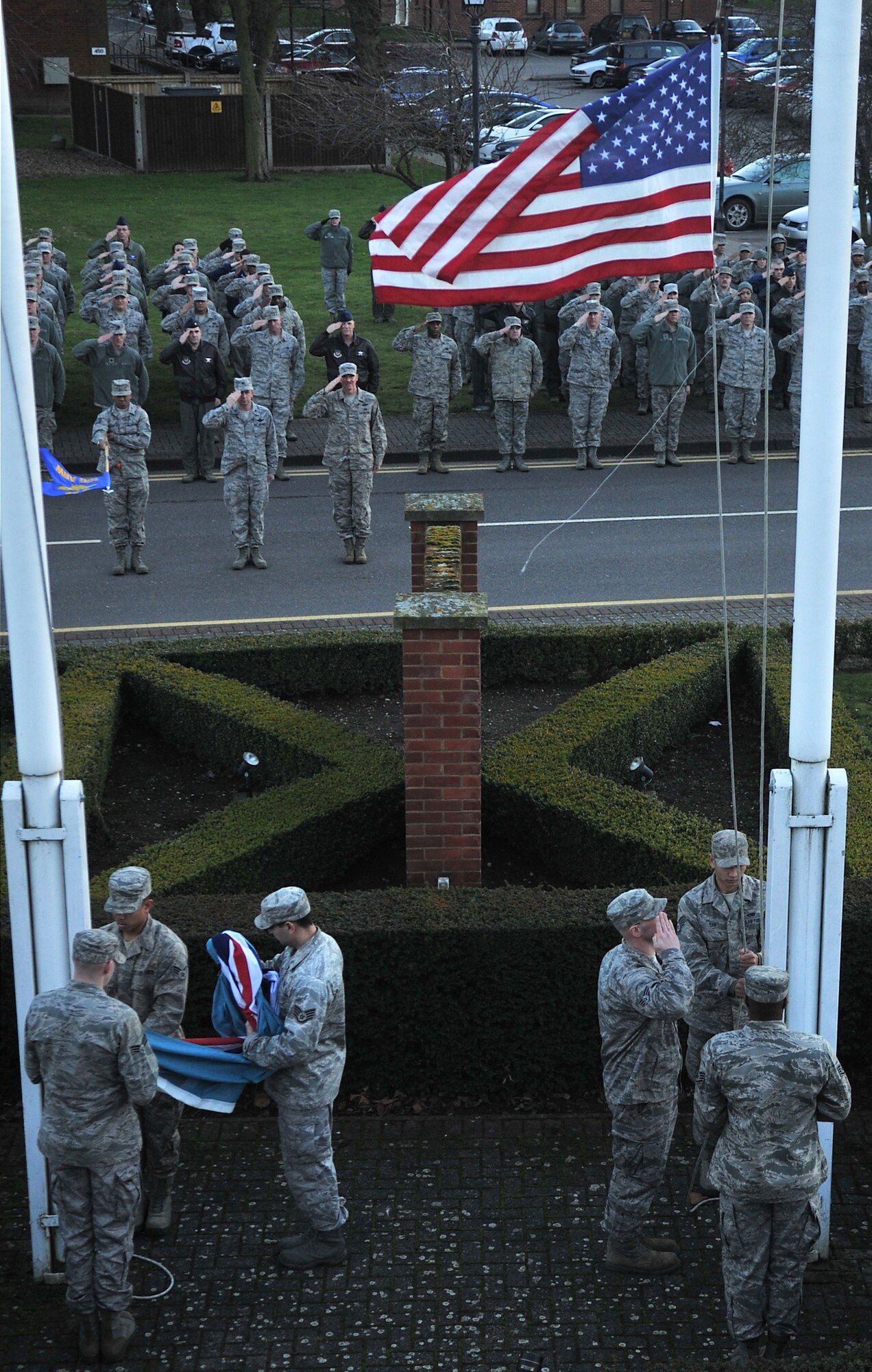 Team Mildenhall honor guardsmen lower the flag during a retreat ceremony Jan. 30, 2013, at RAF Mildenhall, England. The ceremony was held in honor of Chief Master Sgt. Christopher Powell, 100th Air Refueling Wing command chief, as he prepares to retire from active duty. Airmen from multiple squadrons participated in the ceremony to honor Powell’s upcoming retirement after 30 years of active duty service. (U.S. Air Force photo by Senior Airman Jerilyn Quintanilla/Released) 