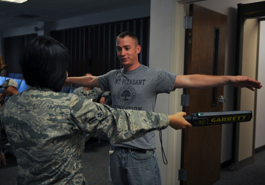 U.S. Air Force Airman 1st Class Jesly Galang, 23d Logisitics Readiness Squadron air terminal operations, checks for metal on Staff Sgt. Lee Runey, 71st Aircraft Maintenance Unit crew chief, at Moody Air Force Base, Ga., Jan. 29, 2013. Members of the 23d Maintenance Group, 347th Rescue Group and 23d Logistics Readiness Squadron deployed to Italy to support overseas operations.  (U.S. Air Force photo by Airman 1st Class Olivia Bumpers/Released)
