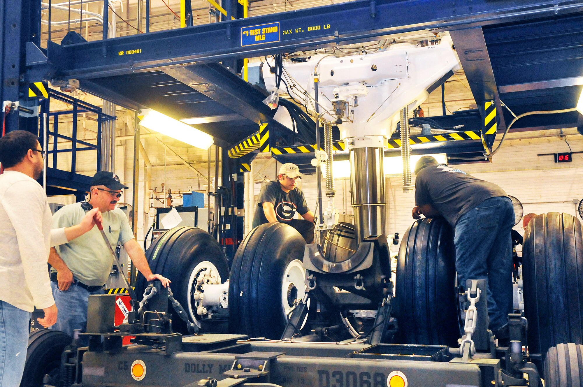 Workers in the C-5 Landing Gear Shop remove a completed landing gear from a work stand. (U. S. Air Force photo/Sue Sapp)
