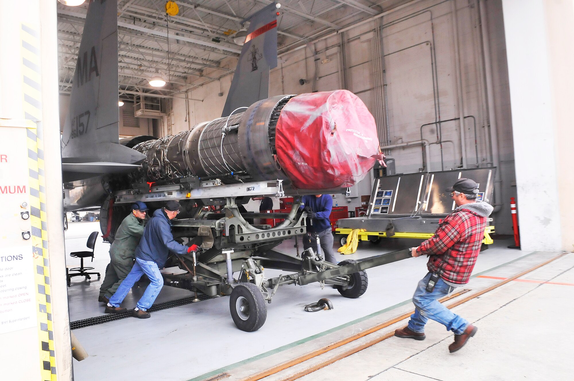 F-15 engine shop workers remove an engine from an F-15. The F-15 Engine Shop received its VPP Gold Banner in January. (U. S. Air Force photo/Sue Sapp)