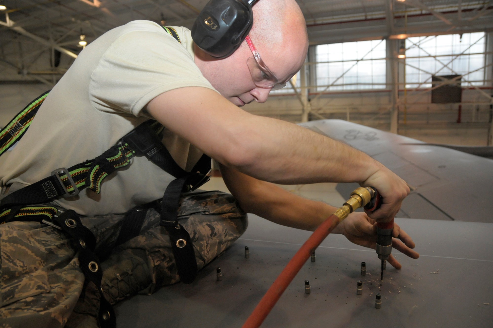 Staff Sgt. Brian Harris, 191st Maintenance Squadron, prepares to cut an opening in the top of a KC-135 Stratotanker at Selfridge Air National Guard Base, Mich., Jan. 30, 2013.Tthe opening will accommodate an additional antennae on the aircraft, which will allow it to serve as a platform for testing a prototype of a new aircraft defense system. The aircraft is assigned to the 127th Wing, Michigan Air National Guard. (Air National Guard photo by Brittani Baisden)