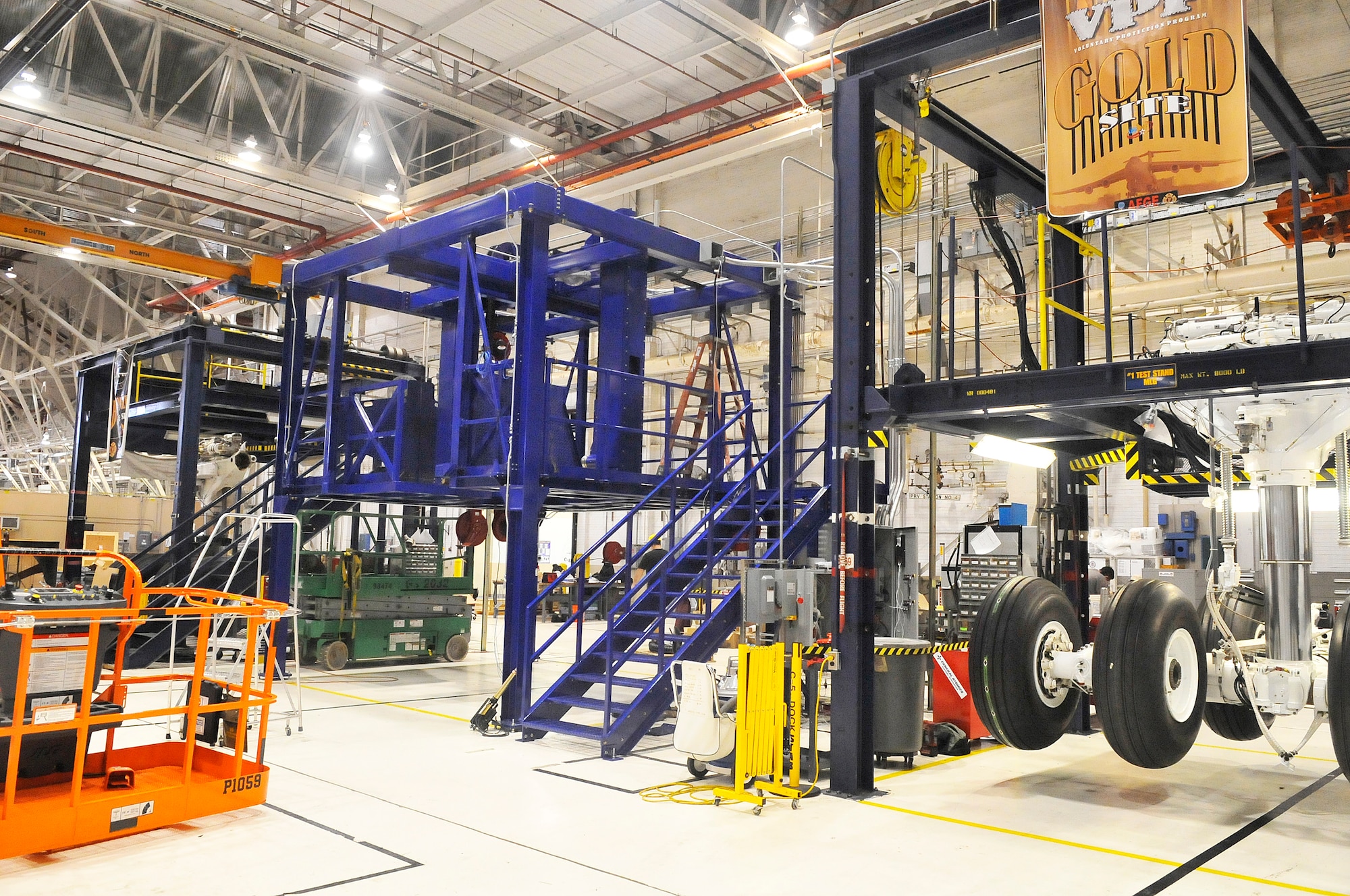 A new work stand is installed between 2 existing lifts in the C-5 Landing Gear Shop. (U. S. Air Force photo/Sue Sapp)