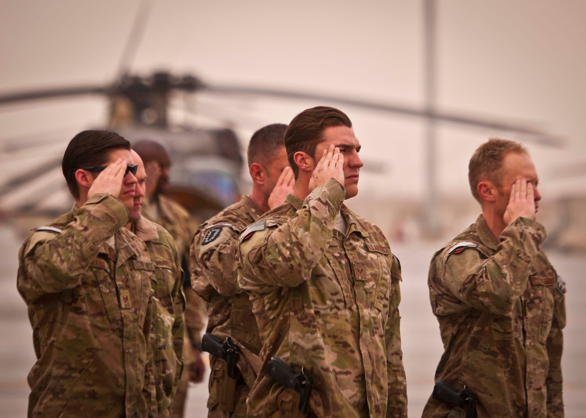 Airmen salute at a ceremony Jan. 30 at Kandahar Airfield marking the inactivation of the 46th Expeditionary Rescue Squadron at Camp Bastion, including a detachment at KAF, and the redeployment of the 59th ERQS, which will not be replaced. The rescue mission at KAF draws to a close after 11 years, during which crews sat alert for 97,000 hours and saved nearly 1,200 lives. (U.S. Air Force photo/Senior Airman Scott Saldukas) 