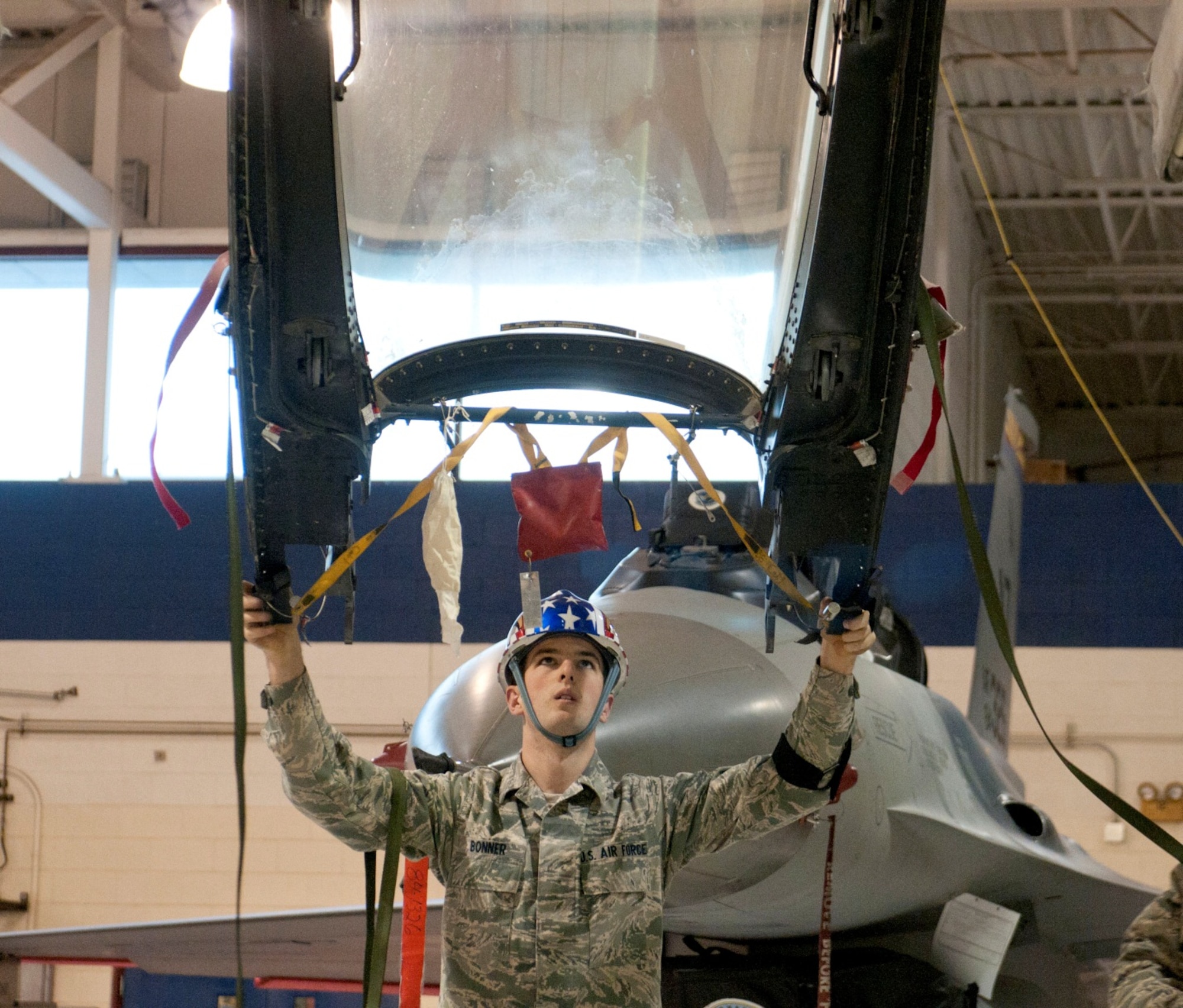 U. S. Air Force Airman 1st Class Jacob Bonner, an Aircrew Egress Systems Specialist, guides an F-16 canopy to a canopy dolly for scheduled egress time change maintenance in Hangar 12 at the 162nd Fighter Wing, January 13, 2013. Bonner is one of many specialists working to ensure the life support systems for the F-16 Fighting Falcon remain serviceable. (U.S. Air Force photo by Tech. Sgt. Hollie A. Hansen/Released) 