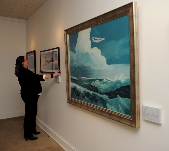 Amy Russell, Barksdale Global Power Museum director, adjusts a painting on Barksdale Air Force Base, La., Jan. 30. The museum offers a wide variety of displays and exhibits. In the future, the museum will offer new exhibits which tell the story of the 2nd Bomb Wing. (U.S. Air Force photo/Airman 1st Class Benjamin Gonsier)