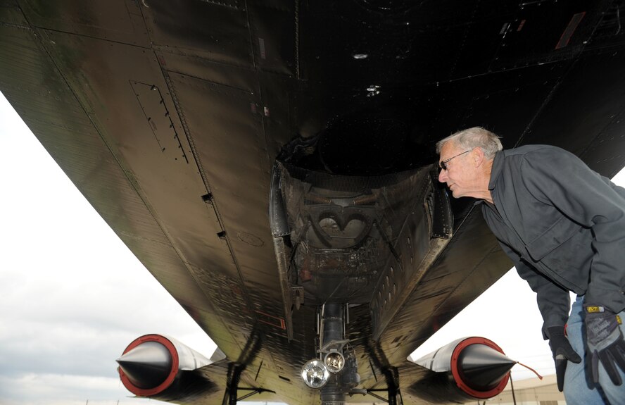 John Henry, Barksdale Global Power Museum volunteer, looks for masking tape to remove on an SR-71 Blackbird after it received a paint job on Barksdale Air Force Base, La., Jan. 30. Retired in 1990, the SR-71 served in the Air Force for 24 years and has broken many flying records during its time in service. (U.S. Air Force photo/Airman 1st Class Benjamin Gonsier)