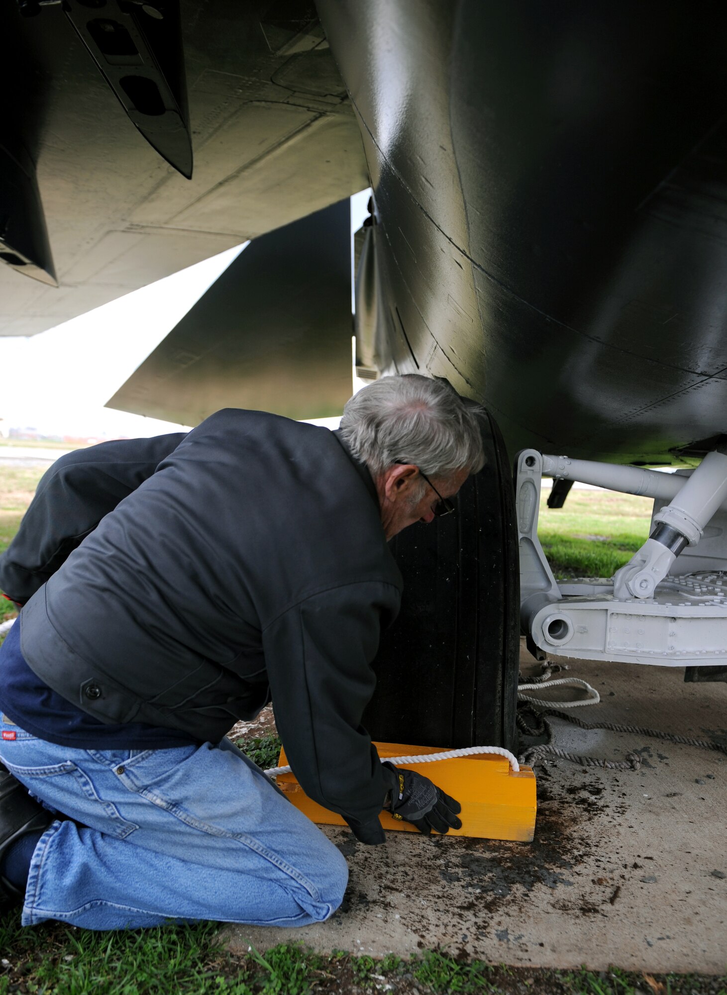 John Henry, Barksdale Global Power Museum volunteer, places a chalk in front of an F-111 tire on Barksdale Air Force Base, La., Jan. 30. Henry is a retired senior master sergeant and dedicates his time to maintaining the static aircraft on display. (U.S. Air Force photo/Airman 1st Class Benjamin Gonsier)