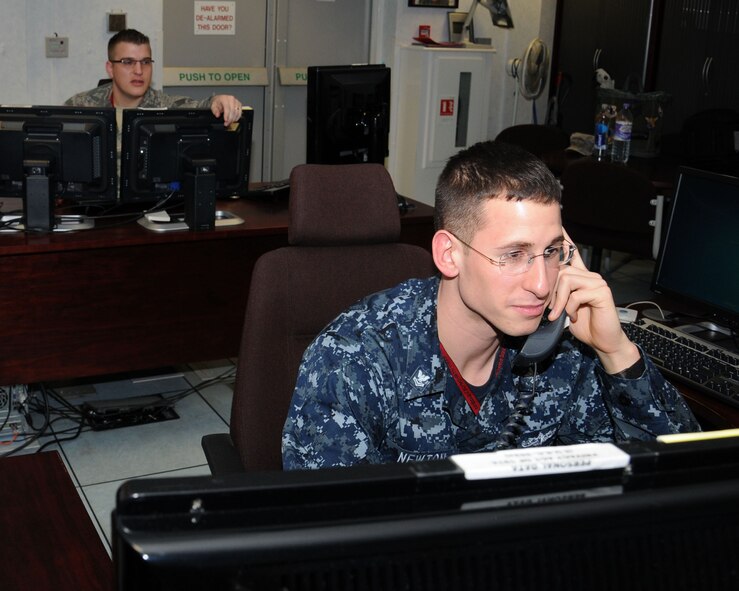 U.S. Navy Petty Officer 2nd Class Shayne Newton, surface warfare specialist watch supervisor, 488th Intelligence Squadron Cryptologic Technician Collection, from Portland, Ore., right, and Tech. Sgt. Christopher Klare from College Station, Texas, left, both 488th IS watch supervisors, cross-cue intelligence requirements with National Agencies Jan. 29, 2013, at RAF Mildenhall, England. The 488th IS operates an around-the-clock operation to meet their mission requirements. (U.S. Air Force photo by Gina Randall/Released)