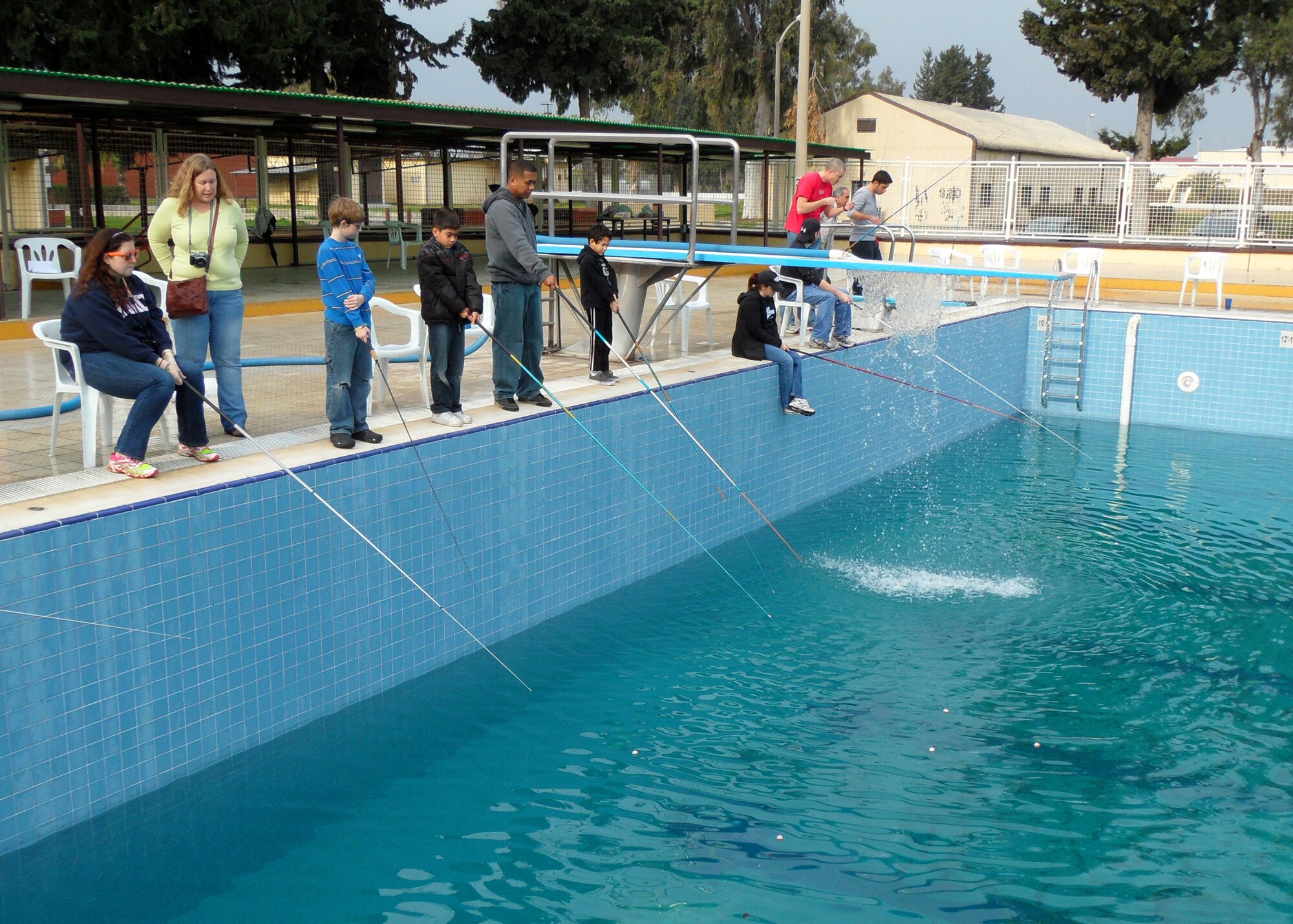 Incirlik members participate in the Fishing Rodeo at the base pool Jan. 26, 2013 held by the Outdoor Recreation Center. The ORC staff stocked the base pool with 400 trout and allowed Incirlik members to fish over the weekend with three fishing sessions each day. The staff also supplied fishing poles and bait then helped clean the fish for families to take home. (US Air Force photo by Staff Sgt. Veuril McDavid/Released)