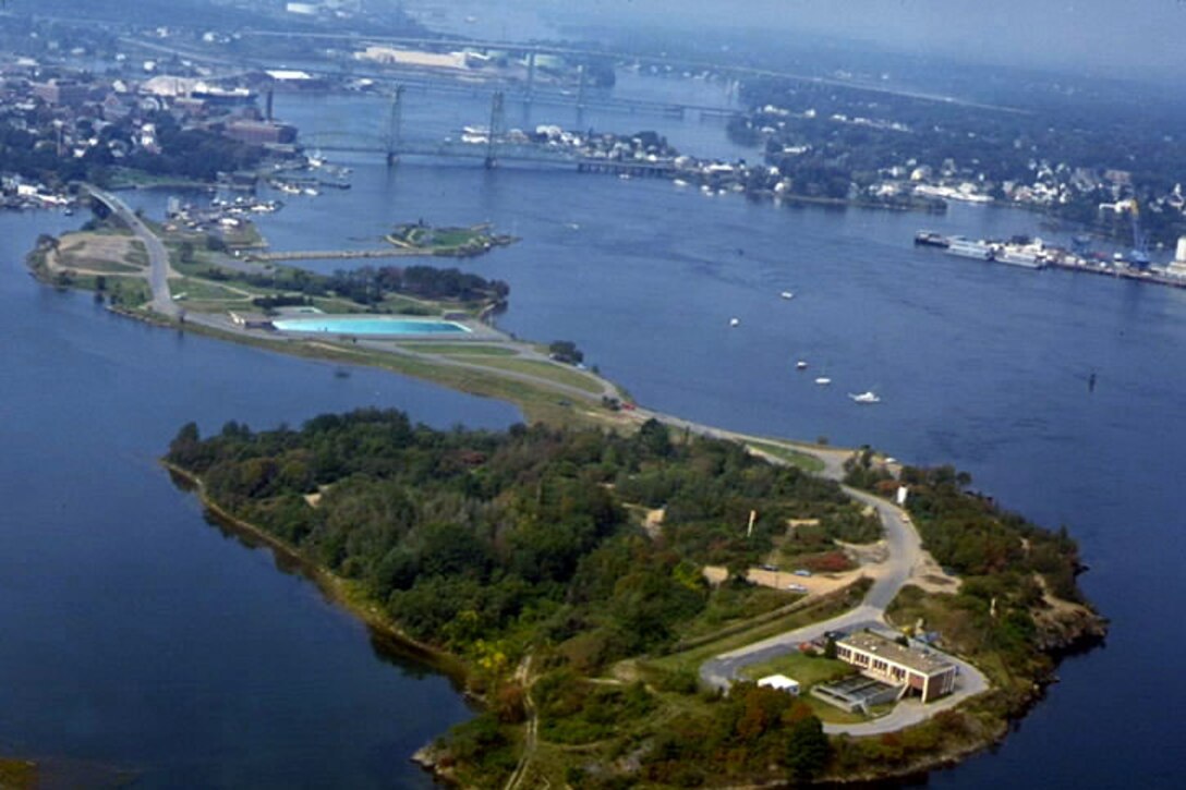 Aerial view of Portsmouth Harbor. Portsmouth Harbor is located on the Piscataqua River, which makes up a portion of the Maine-New Hampshire border. Portsmouth Harbor stretches across the communities of Kittery and Eliot, Maine, and Portsmouth, Newington, and New Castle, New Hampshire. 
