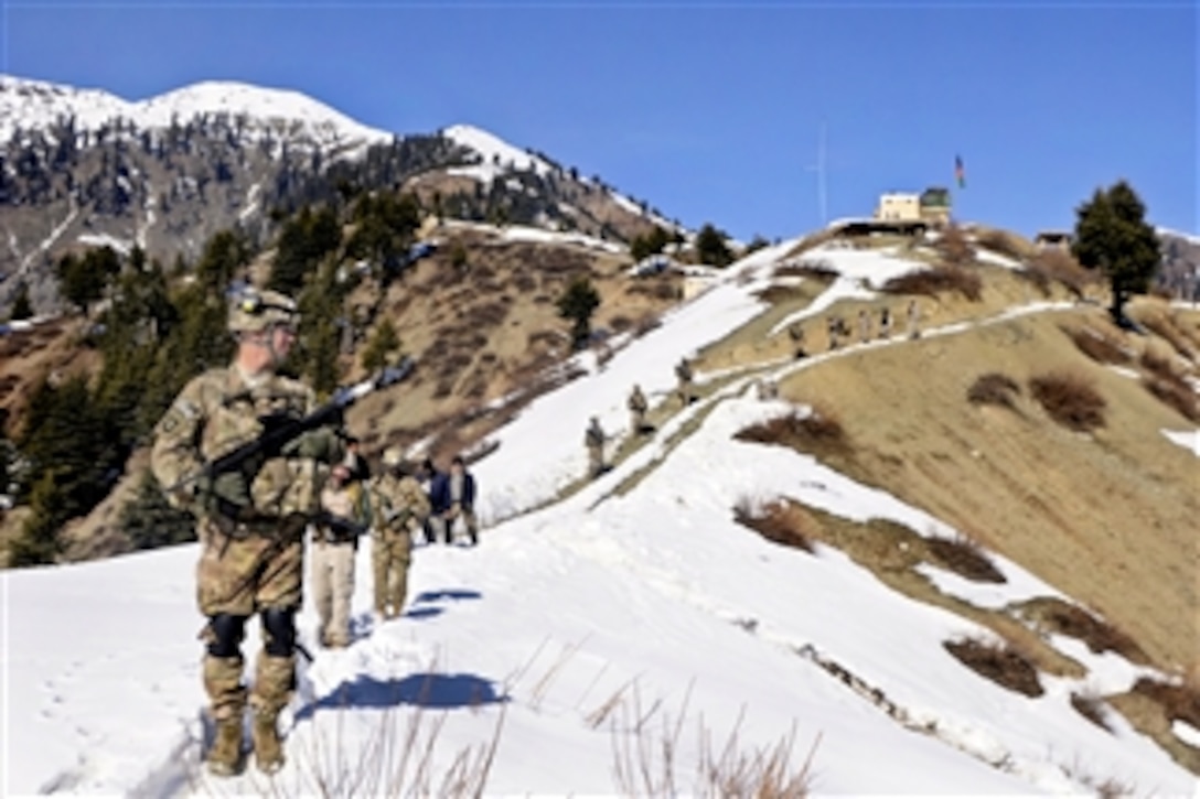 U.S. Army soldiers and Afghan border police walk a snowy ridgeline as they leave Observation Point 12 along the Afghanistan-Pakistan border to a waiting UH-60 Black Hawk helicopter in the Kunar province of Afghanistan on Jan. 21, 2013. 