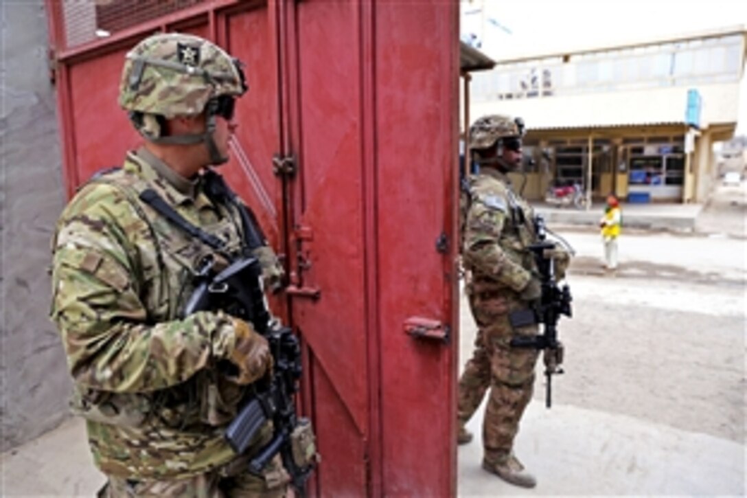 U.S. Army Spc. Michael Jones, left, and U.S. Army Staff Sgt. Roderick Cooper, prepare for a dismounted patrol outside the Directorate of Information and Culture building in Farah City, Afghanistan, Jan. 30, 2013. Jones and Cooper are assigned to Provincial Reconstruction Team Farah.