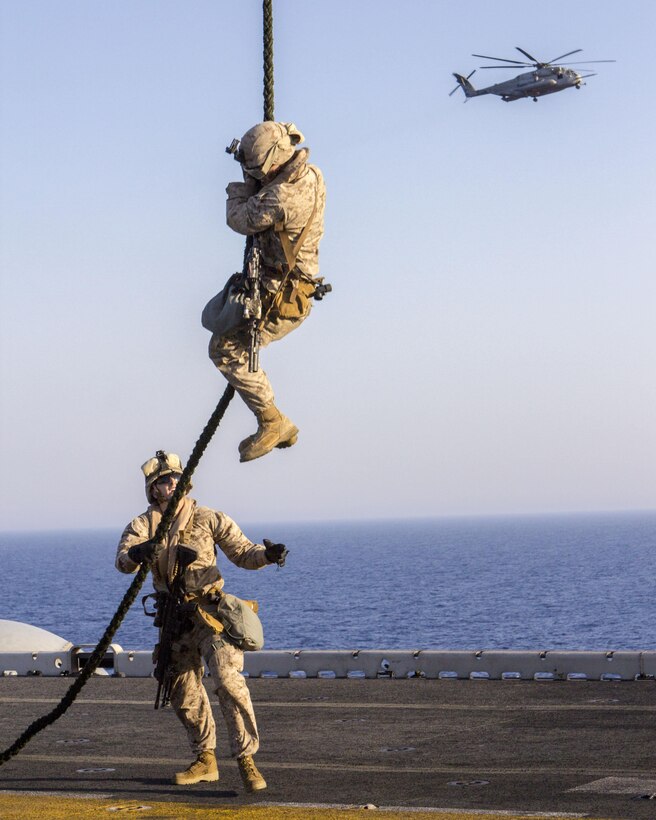 A U.S. Marine assigned to Battalion Landing Team 3/2, 26th Marine Expeditionary Unit (MEU), fast ropes from a CH-53 Super Stallion assigned to Marine Medium Tiltrotor Squadron (VMM) 266 (Reinforced), 26th MEU, during familiarization training on the flight deck of the USS Kearsarge (LHD 3), at sea, June 30, 2013. The 26th MEU is a Marine Air-Ground Task Force forward-deployed to the U.S. 5th Fleet area of responsibility aboard the Kearsarge Amphibious Ready Group serving as a sea-based, expeditionary crisis response force capable of conducting amphibious operations across the full range of military operations. (U.S. Marine Corps photograph by Sgt. Christopher Q. Stone, 26th MEU Combat Camera/Released)