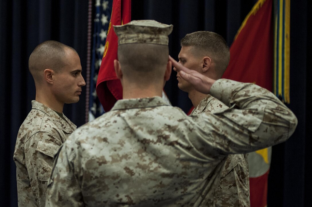 Capt. David Bouchard, left, former Company A commander, hands the Co. A guidon to Capt. Tyler Tidwell, right, incoming Co. A commander, during a change of command ceremony at Marine Barracks Washington, D.C., July 1. The guidon is a flag carried to show a units identity. 