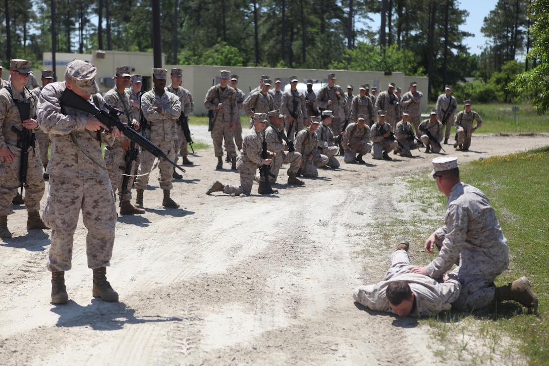 Instructors with the Military Operations in Urban Terrain facility aboard Marine Corps Base Camp Lejeune demonstrate the proper way to detain a possible suspect in a combat zone during the Company B M.O.U.T training at the facility aboard Marine Corps Base Camp Lejeune May 9. Company B of Headquarters and Support Battalion marked the first time a non-deployable unit attended this training. (Photo by Pfc. Justin A. Rodriguez/released)