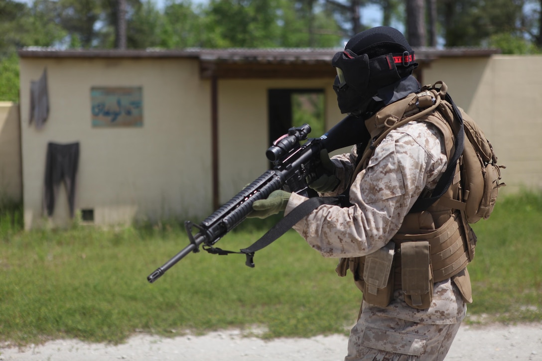 A Headquarters and Support Battalion Company B Marine patrols the streets of the Military Operations in Urban Terrain facility during Company B Military Operations on Urban Terrain training aboard Marine Corps Base Camp Lejeune May 9. The Marine used simulated 5.56 mm rounds for the training. (Photo by Pfc. Justin A. Rodriguez/released)