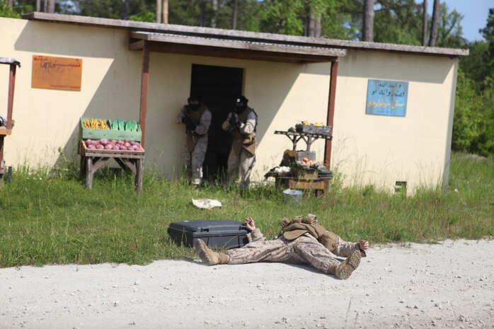 Headquarters and Support Battalion Company B Marines effectively engage an enemy during the Company B Military Operations in Urban Terrain training at the facility aboard Marine Corps Base Camp Lejeune May 9. The enemy approached the Marines with a suitcase before they engaged him. Staff non-commissioned officers portrayed enemy forces. (Photo by Pfc. Justin A. Rodriguez/released)