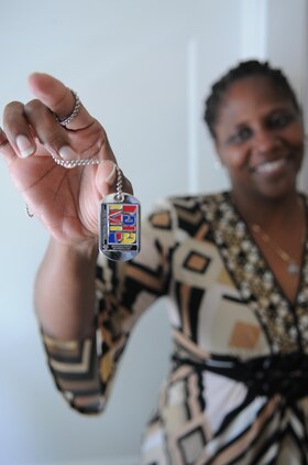 Monique O’Neil, manager of Quantico’s Exceptional Family Member Program, shows off one of the dog tag awards made for the base’s first Special Olympics track and field event, scheduled for Sept. 7. On the other side is the Special Olympics logo. 