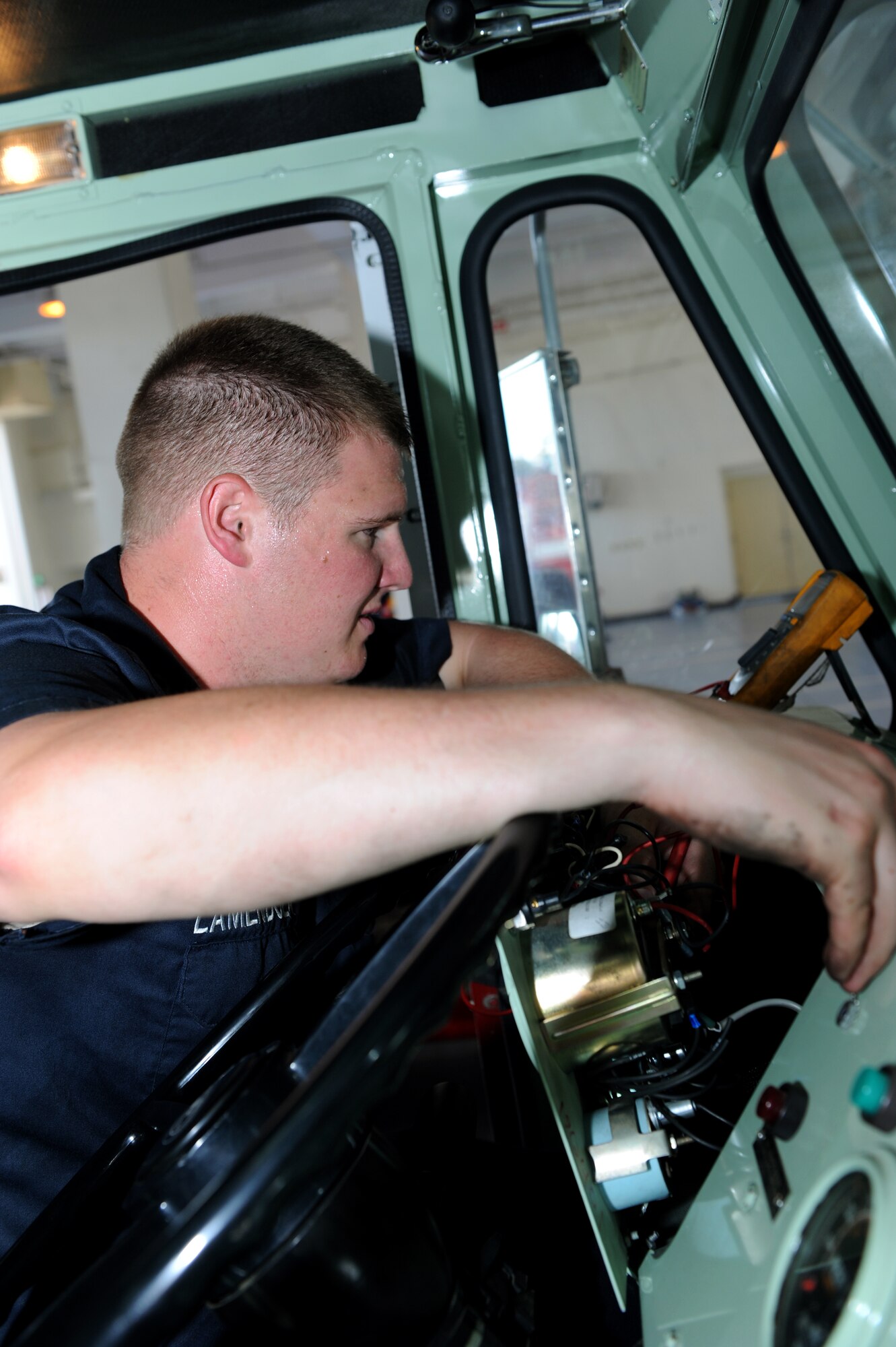 U.S. Air Force Senior Airman Nicholas Lamendola, 18th Logistics Readiness Squadron fire truck maintenance technician, checks for power flow to the switches of a P19 fire truck on Kadena Air Base, Japan, July 1, 2013. 18th LRS fire truck technicians enable the 18th Civil Engineer Squadron Fire and Emergency Services flight to respond to residential and work place emergencies. (U.S. Air Force photo by Airman 1st Class Hailey R. Davis/Released)