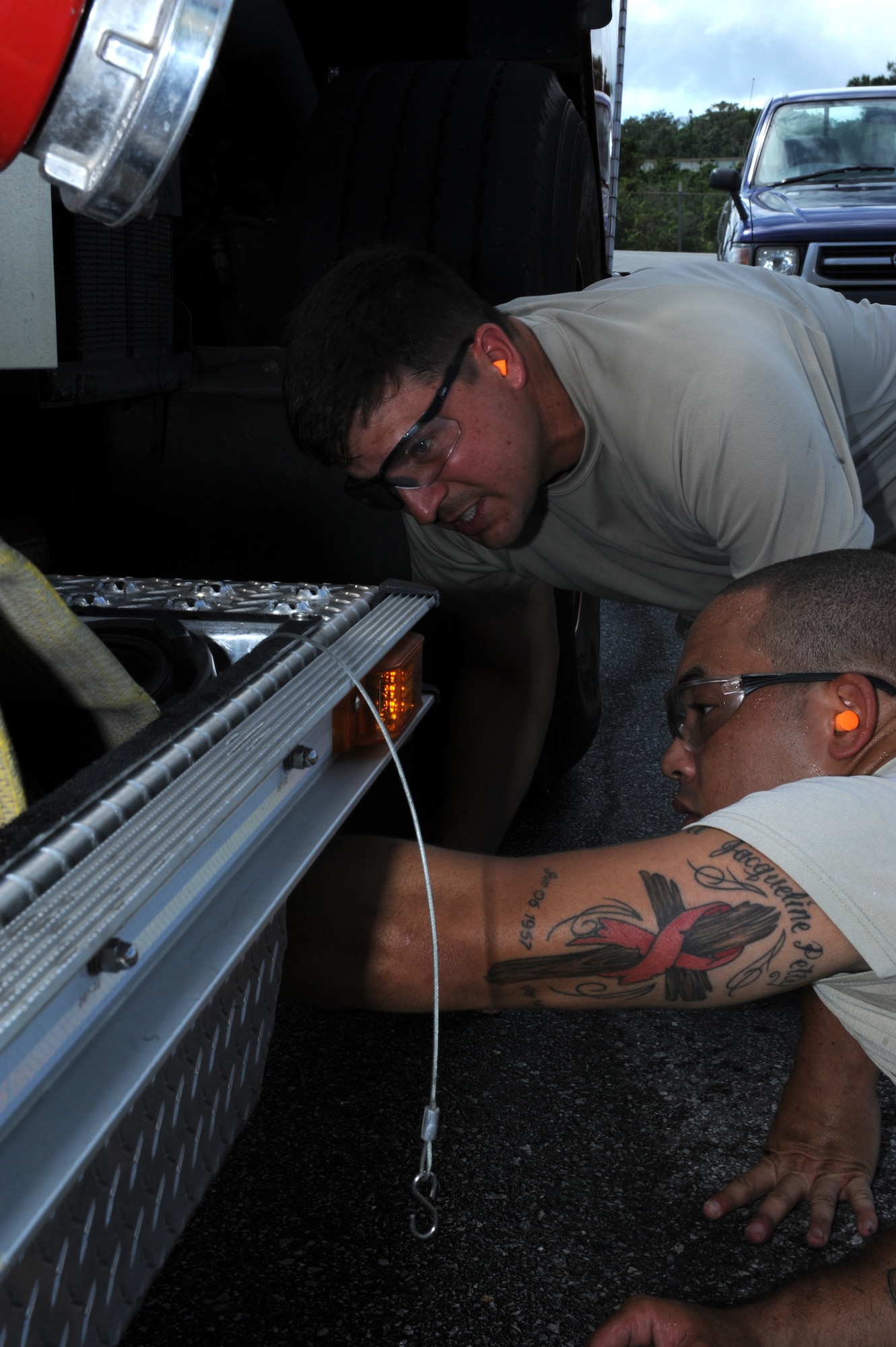 U.S. Air Force Tech. Sgt. Matthew Chappell, 18th Logistics Readiness Squadron fire truck maintenance NCO in charge, and Staff Sgt. Justin Petty, 18th LRS fire truck maintenance technician, review a water leak under a fire truck on Kadena Air Base, Japan, July 1, 2013. 18th LRS fire truck technicians provide maintenance on the wing's aircraft crash and rescue trucks, structural fire trucks and fire suppression equipment. (U.S. Air Force photo by Airman 1st Class Hailey R. Davis/Released)