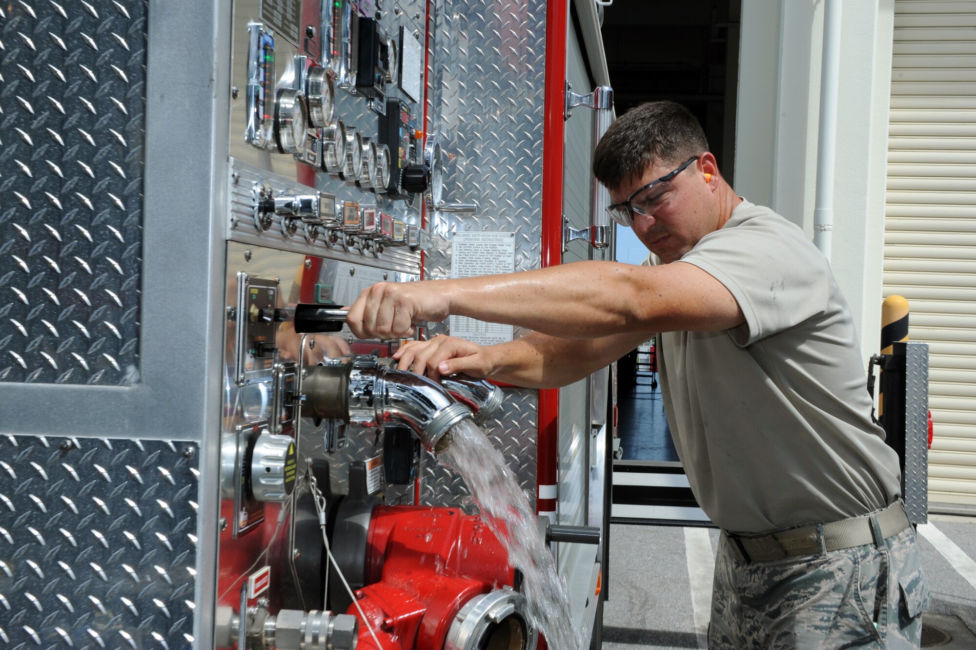 U.S. Air Force Tech. Sgt. Matthew Chappell, 18th Logistics Readiness Squadron fire truck maintenance NCO in charge, releases water from a pump on a fire truck on Kadena Air Base, Japan, July 1, 2013. 18th LRS fire truck technicians provide maintenance on the wing's aircraft crash and rescue trucks, structural fire trucks and fire suppression equipment as well as enable the 18th Civil Engineer Squadron Fire and Emergency Services flight to respond to residential and work place emergencies. (U.S. Air Force photo by Airman 1st Class Hailey R. Davis/Released)
