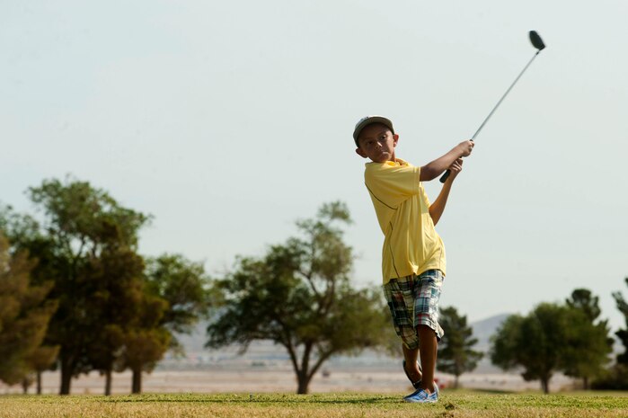 Miguel Maisonet, son of Lt. Col. Anthony Maisonet, 99 Air Base Wing director of staff, tees off during the annual Sunrise Vista Junior Kids Golf Clinic June 28, 2013, at Nellis Air Force Base, Nev. The clinic enables golfers the chance to teach future generations of golfers. (U.S. Air Force photo by Senior Airman Daniel Hughes)