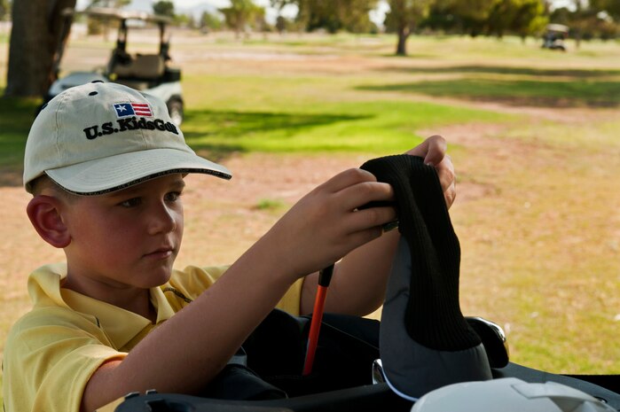 Caleb Beeker, son of U.S. Air Force Lt. Col. Kevin Beeker, 549th Combat Training Squadron director of operations, puts away his club after teeing off during the annual Sunrise Vista Junior Kids Golf Clinic June 28, 2013, at Nellis Air Force Base, Nev. The clinic instructed children on basic golf knowledge. (U.S. Air Force photo by Senior Airman Daniel Hughes)