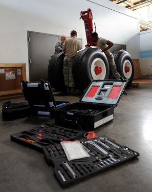 During training, maintenance qualification training program students carry cases full of tools to be used when fixing an aircraft in the hangar at Fairchild Air Force Base, Wash. MQTP is a course that lasts for approximately four months where instructors train brand new Airmen straight from technical training. (U.S. Air Force photo by Airman 1st Class Janelle Patiño/Released)