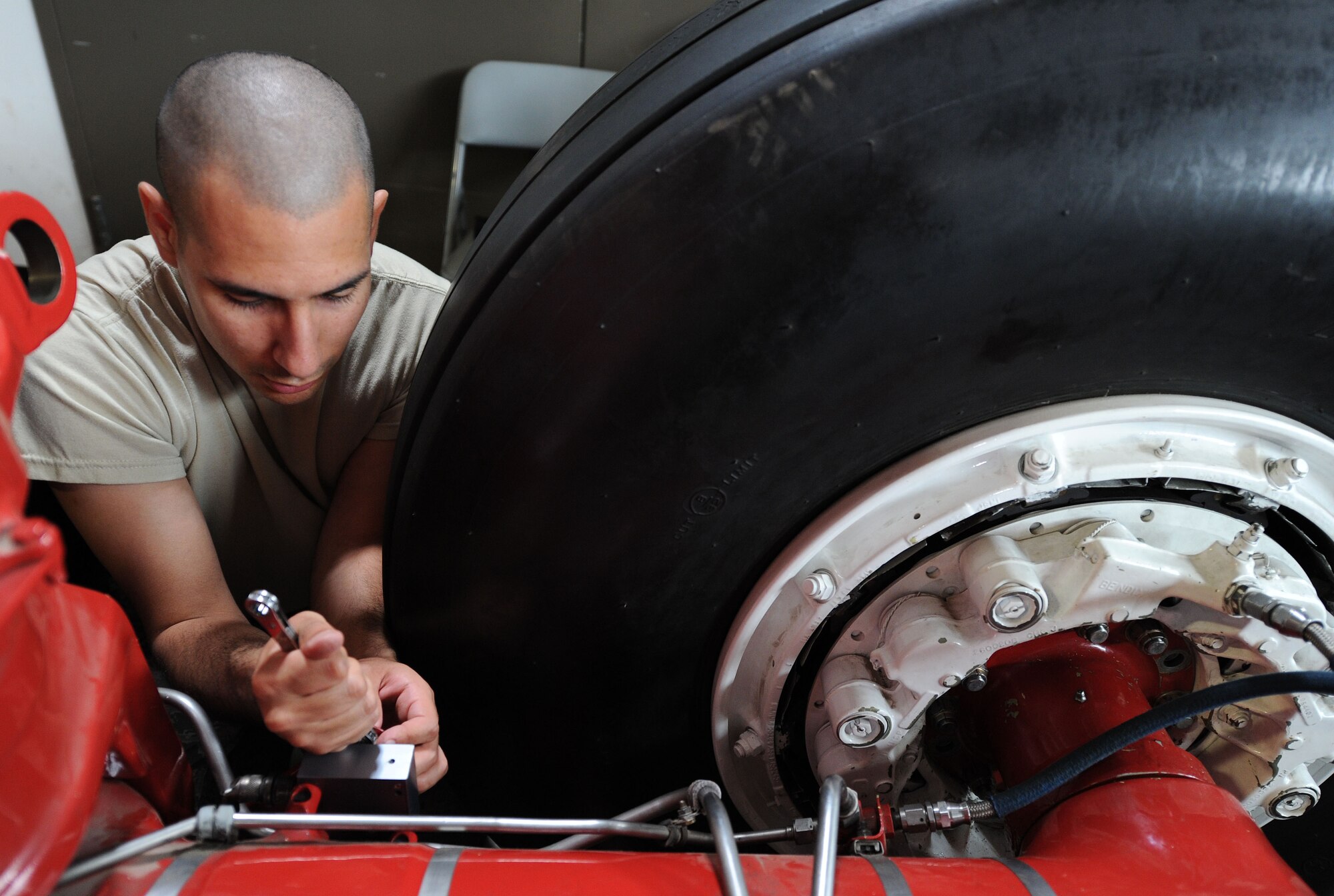 Airman 1st Class Christopher Yanes, a maintenance qualification training program student, removes the truck level switch of a landing gear during a hands-on training session at Fairchild Air Force Base, Wash., June 28, 2013. The truck level switch is a crucial component of the landing gear, completing a circuit which ensures the gear is safe to raise into the wheel well. (U.S. Air Force photo by Airman 1st Class Janelle Patiño/Released)
