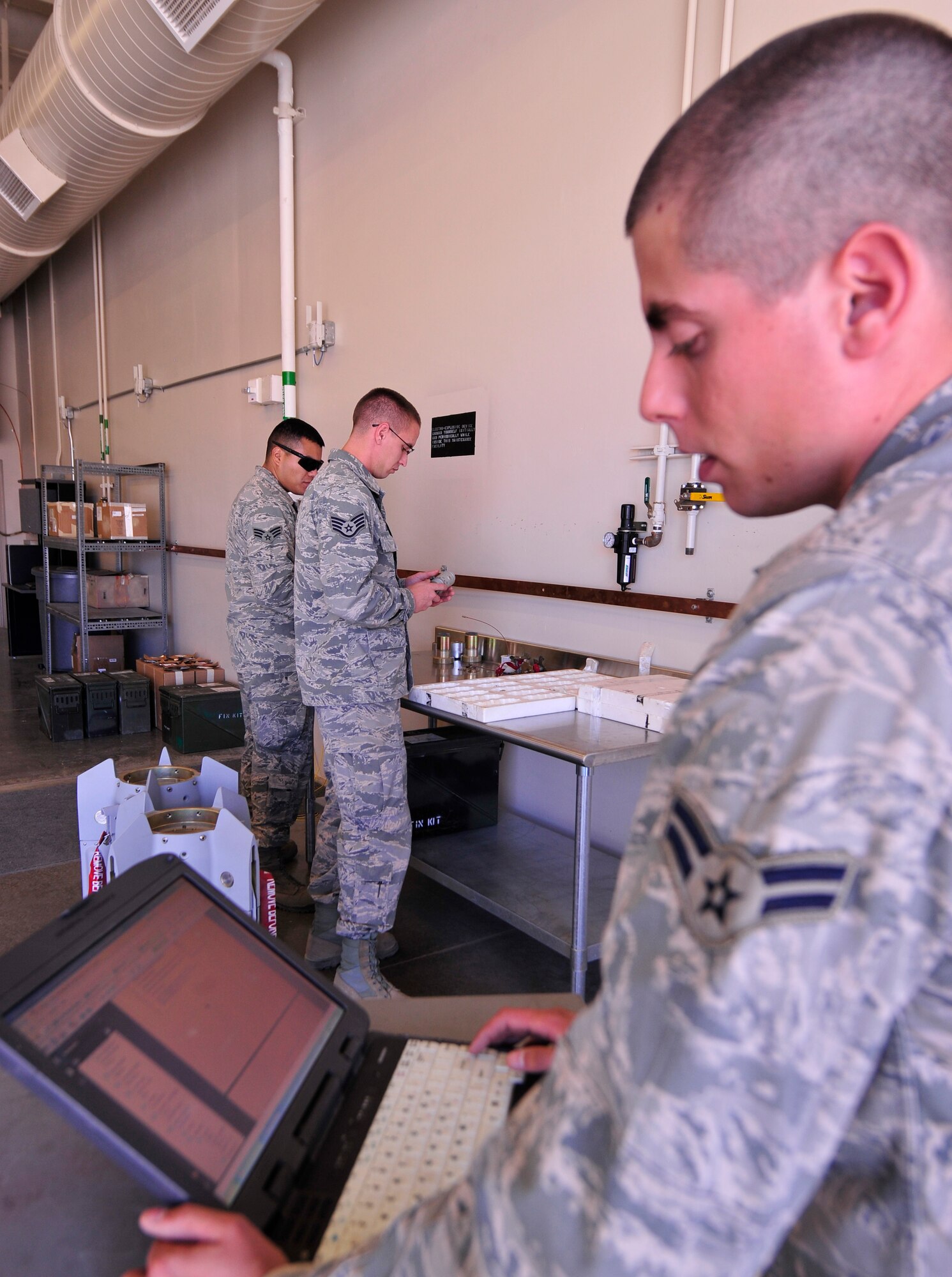 LAS VEGAS, Nev. -- An Airman, right, gives inspection directions during a GBU-12 bomb build in compliance with the training operations required for the assembly June 19, 2013. Each bomb is constructed through a series of instructions and inspections from the beginning to end, ensuring each one is built in uniform with all others. The GBU-12s built were used for live munitions in the 432nd Wing Hunt, a competition between multiple remotely piloted aircraft squadrons, which takes place June 23-28. The competition offers an opportunity for training and demonstration of skill level. (U.S. Air Force photo by Senior Airman A.K./Released)