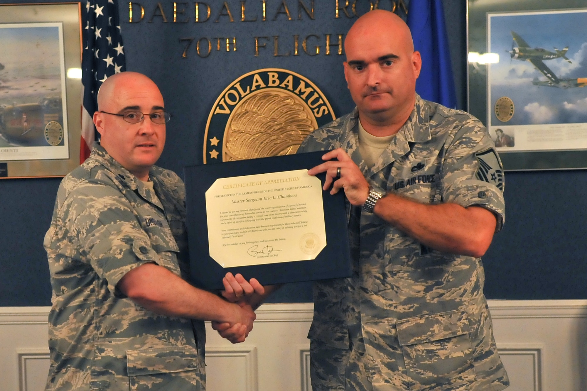 U.S. Air Force Master Sgt. Eric Chambers, U.S. Air Forces Central armament systems functional manager, receives his certificate of retirement from Lt. Col. Kevin Umbaugh, AFCENT aircraft and munitions maintenance chief, Shaw Air Force Base, S.C., June 28, 2013. A certificate of retirement is received in most cases after serving 20 or more years in the military. (U.S. Air Force photo by Airman 1st Class Ashley L. Gardner/Released)