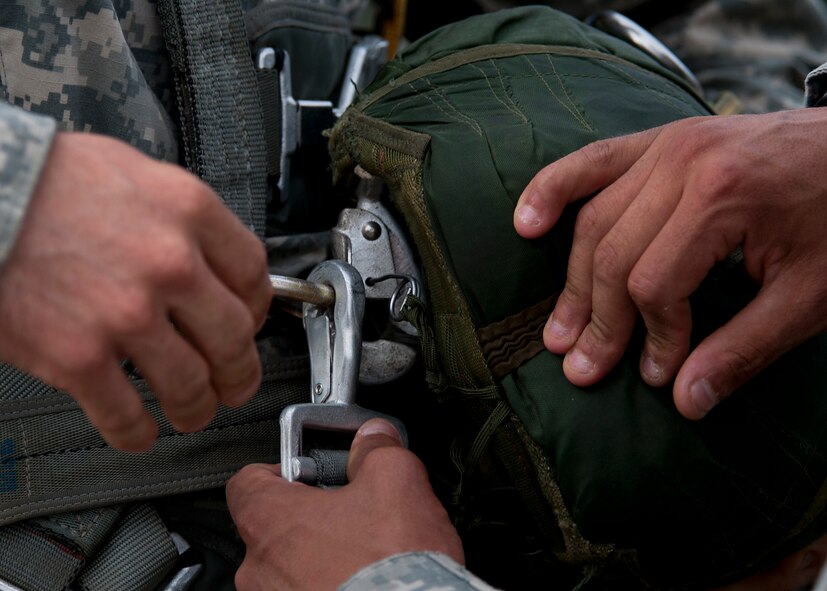 A U.S. Army Soldier from the 82nd Airborne Division rigs up his parachute in preparation for a jump during the Joint Operation Access Exercise at Pope Field, N.C., June 24, 2013More than 2,400 paratroopers jumped out of C-130Js assigned to Dyess, Air Force Base, Texas, during the 12-day exercise. (U.S. Air Force photo by Airman 1st Class Damon Kasberg/Released)
