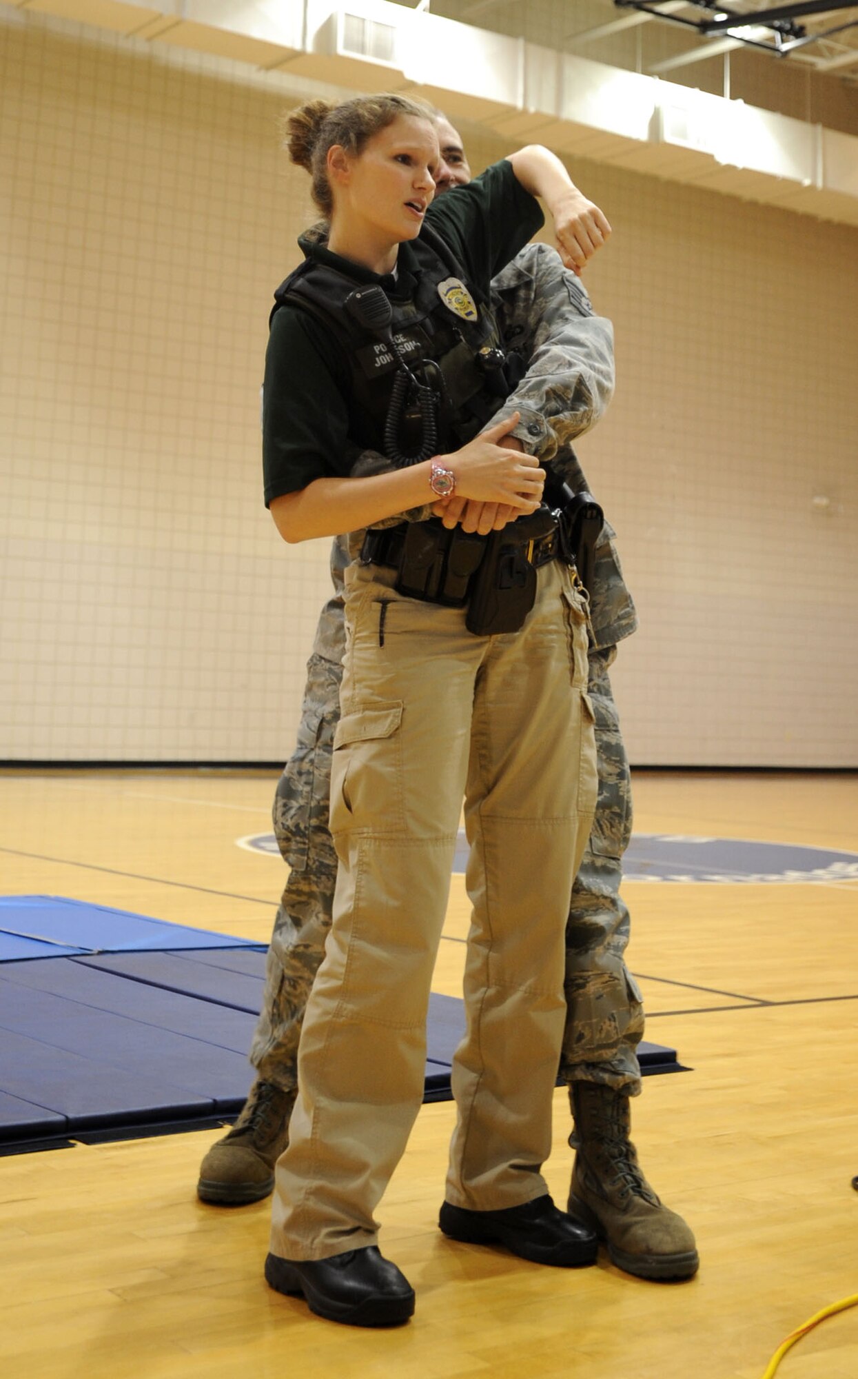 Rebecca Johnson, Wichita Police Department patrol officer and department defensive tactics instructor, demonstrates self-defense maneuvers during a women’s self defense class June 27, 2013, at McConnell Air Force Base, Kan. Johnson and other presenters stressed the importance of situational awareness and preparedness and to maintain a survival mentality in the instance of assault. (U.S. Air Force photo/Senior Airman Laura L. Valentine) 