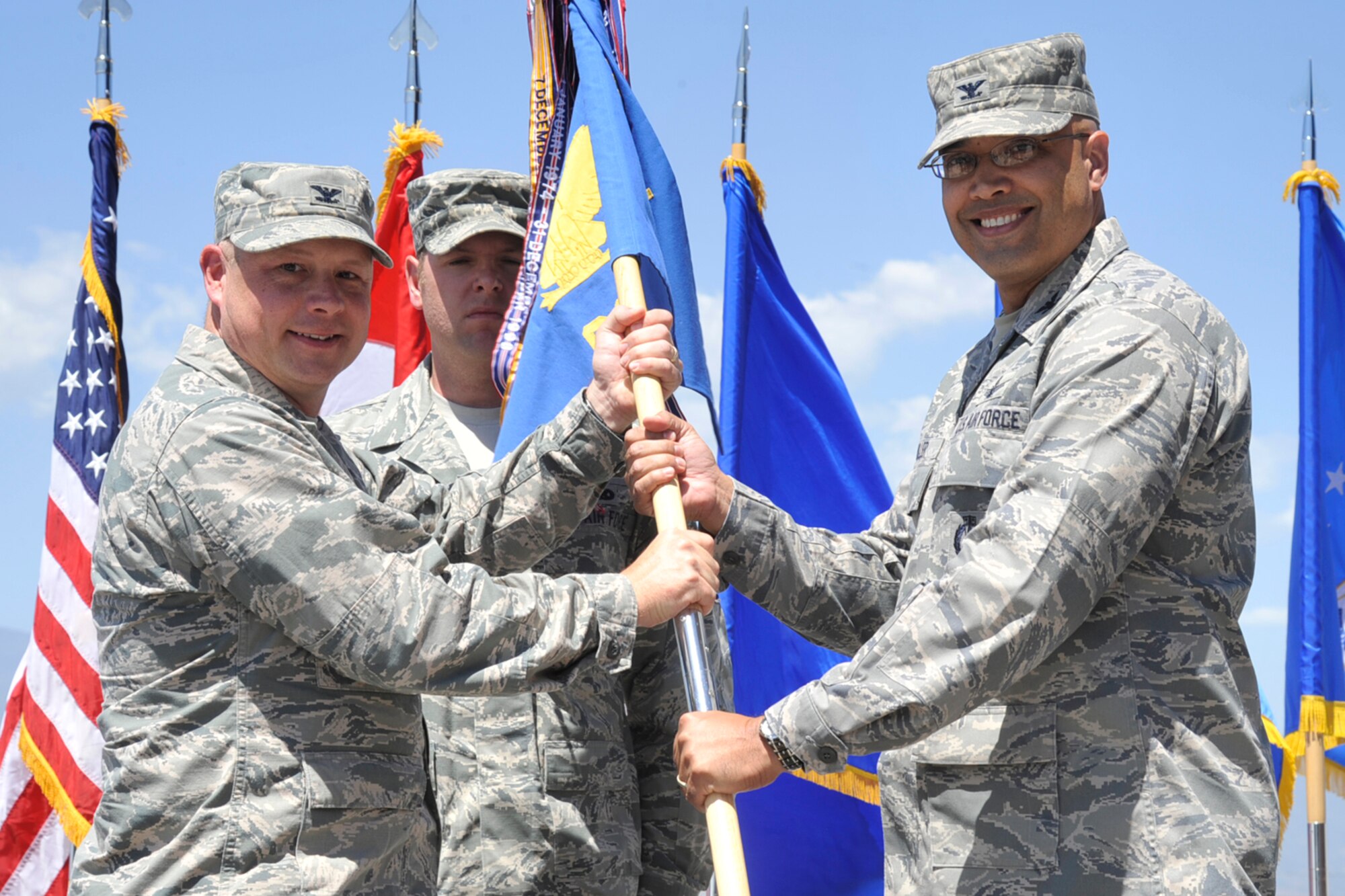 PETERSON AIR FORCE BASE, Colo. – Col. Chris Crawford (left), 21st Space Wing commander, passes command of the 21st Operations Group to Col. David Miller June 26 at building 2027. Miller replaces Lt. Col. Paul Tombarge, outgoing 21st OG commander. Prior to taking command of the 21st OG, Miller was a student at the National War College. (U.S. Air Force photo/Robb Lingley)