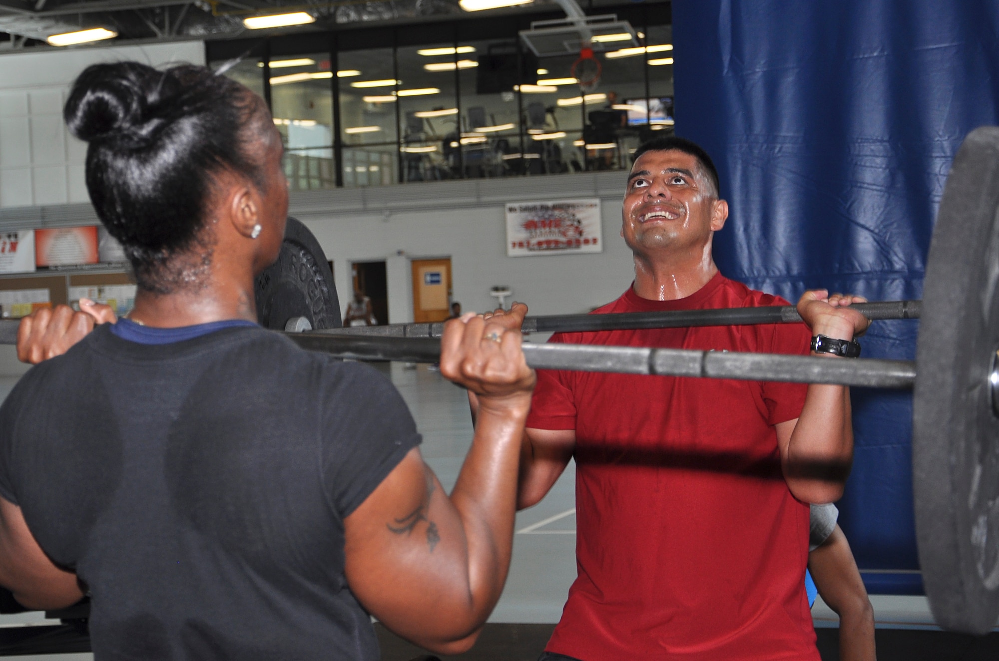 Latrese Grant, a military spouse, and U.S. Army 1st Sgt. Elise Navarrete, 235th Signal Brigade first sergeant, perform push presses together during a Functional Fitness Program “CrossFit” class at Anderson Field House on Fort Eustis, Va., June 24, 2013. Classes teach short-functional movements that are used in everyday life, such a squatting, pushing and pulling. (U.S. Air Force photo by Tech. Sgt. April Wickes/Released)